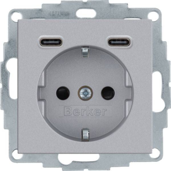 Silberfarbige Wandsteckdose mit zwei USB-Anschlüssen oberhalb einer europäischen Steckdose, Marke Berker.