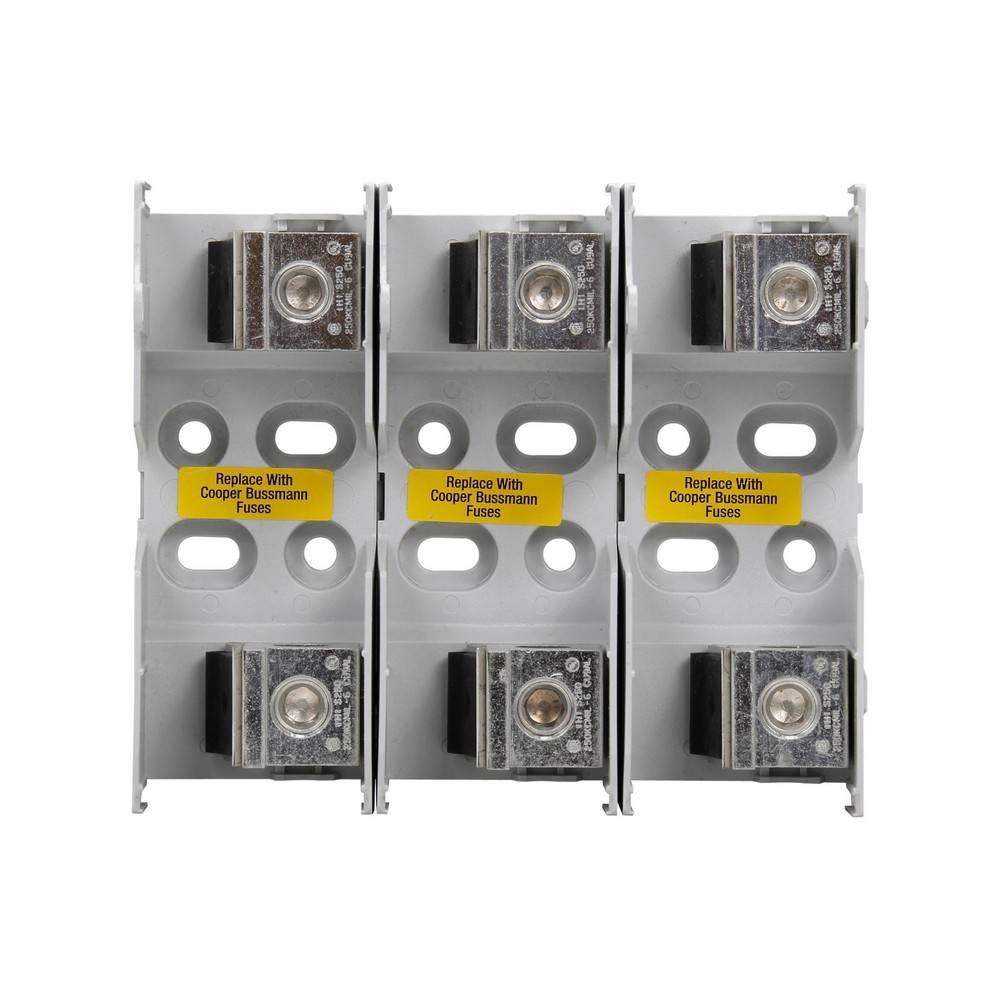 Dreipoliger Elektrosicherungsblock mit sichtbaren Kupfersicherungshaltern und gelben Etiketten mit der Aufschrift „Replace With Cooper Bussmann Fuses