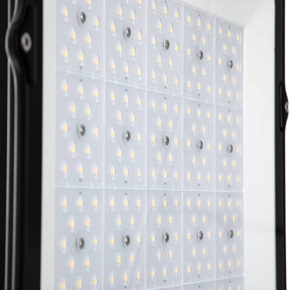 Nahaufnahme eines rechteckigen LED-Lichtpanels mit mehreren Reihen von kleinen gelben Dioden auf einem weißen Gitter, umrahmt von einem schwarzen Gehäuse.