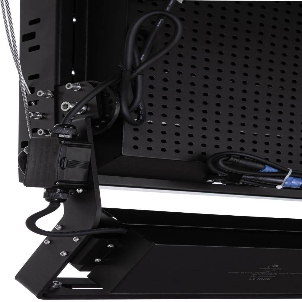 Nahaufnahme einer schwarzen verstellbaren Monitor- oder TV-Halterung mit Kabeln und Schrauben, die an einem perforierten Metallrückenpanel befestigt sind.
