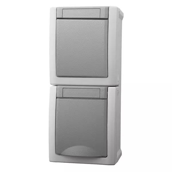 Gestapelte graue Wandschaltermodule in einer Doppel-Elektroinstallationsdose auf weißem Hintergrund.