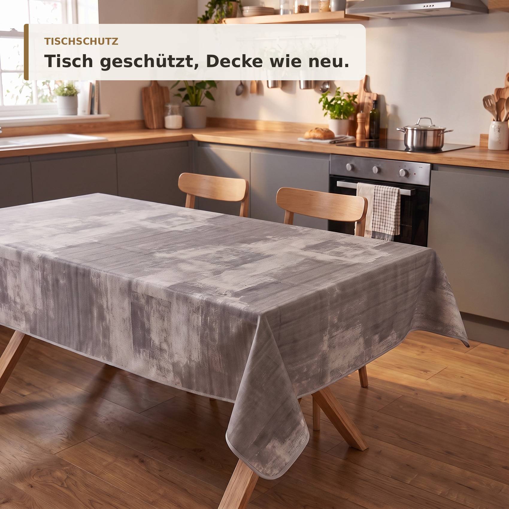 Graue Tischdecke schützt einen Esstisch in einer modernen Küche, mit deutschem Text, der lautet „Tisch geschützt, Decke wie neu."