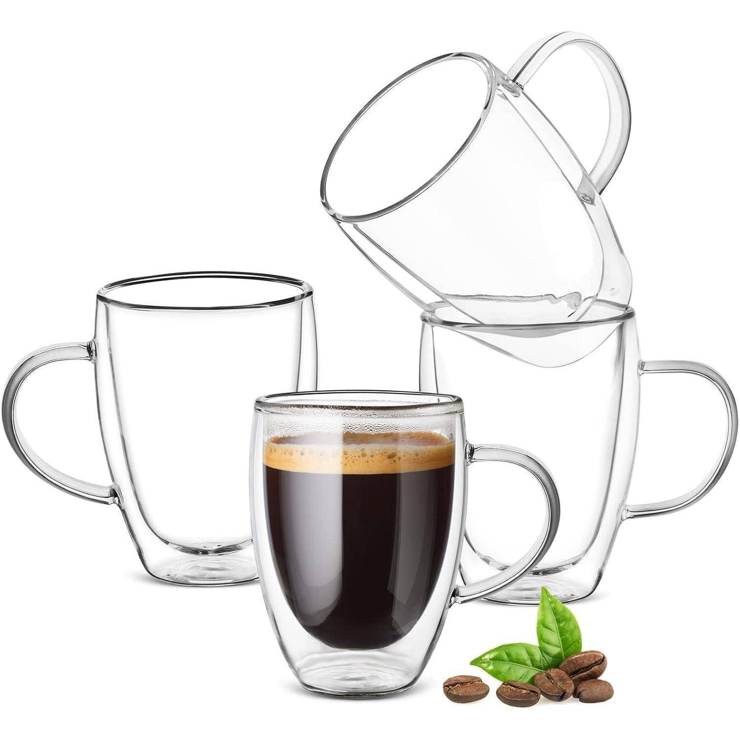 Doppelwandige Glaskaffeetassen, eine gefüllt mit Espresso und Kaffeebohnen mit Minzblättern davor.