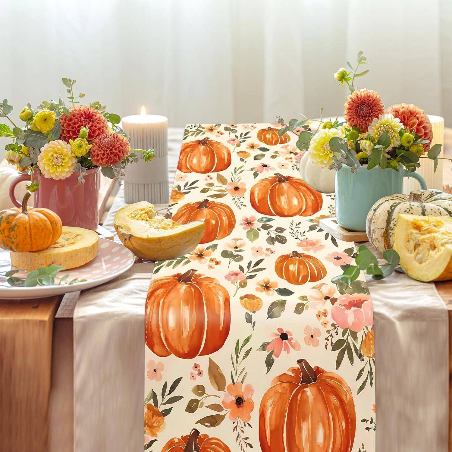 Herbstliche Tischdeckung mit kürbismustertem Läufer, Blumen, Kerzen und aufgeschnittenen Kürbissen und Squash, die auf einem hellen Esstisch angeordnet sind.