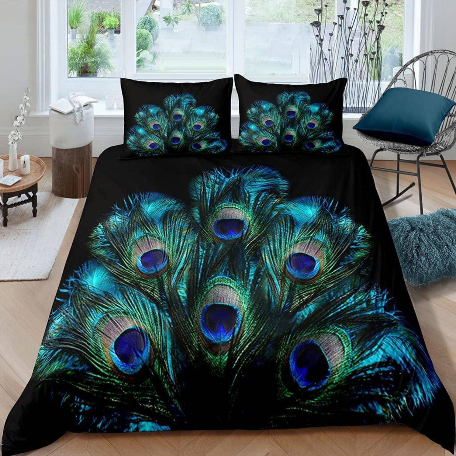 Schwarzes Bettwäscheset mit lebhaftem Pfauenfedern-Design auf der Bettdecke und den Kissenbezügen in einem hellen Schlafzimmer.