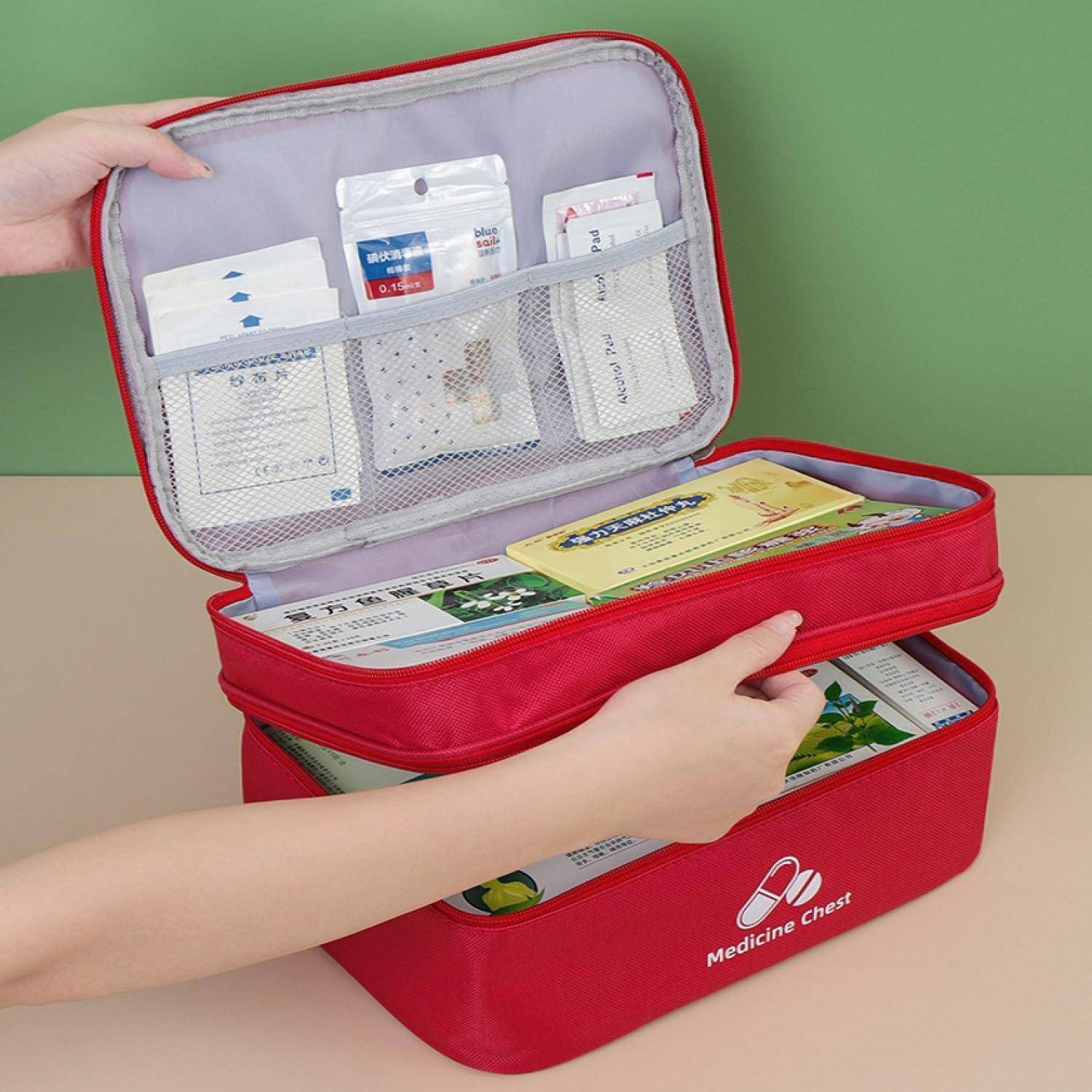 Rote Medizinbox mit geöffnetem Deckel zeigt organisierte Fächer mit Erste-Hilfe-Materialien und Päckchen, während Hände den Deckel heben.