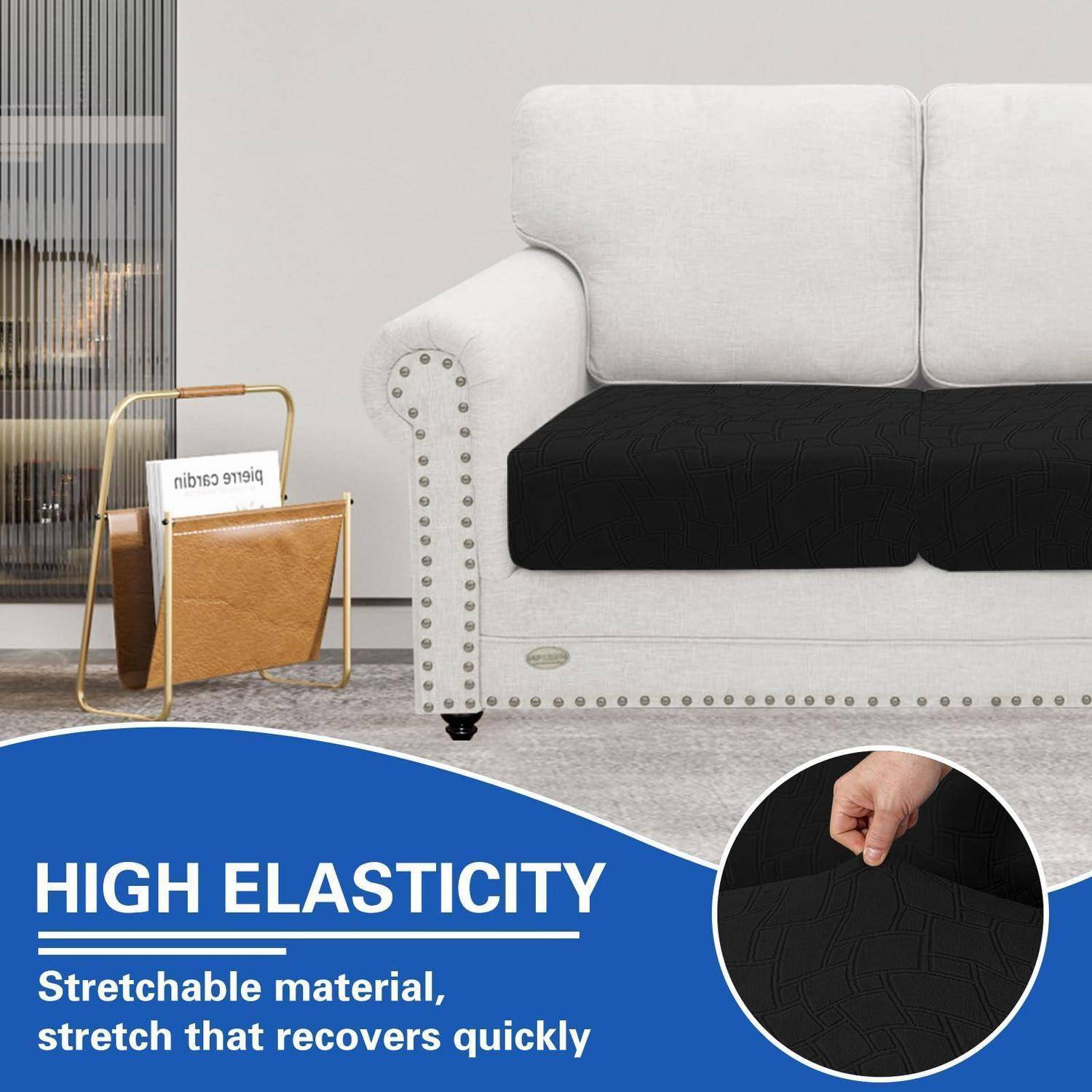 Werbebild eines grauen Sofas mit einer schwarzen dehnbaren Sitzhülle, das eine Hand zeigt, die den Stoff zieht, und den Text „HOHE ELASTIZITÄT" und „Dehnbares Material, Dehnung die sich schnell zurückbildet"".