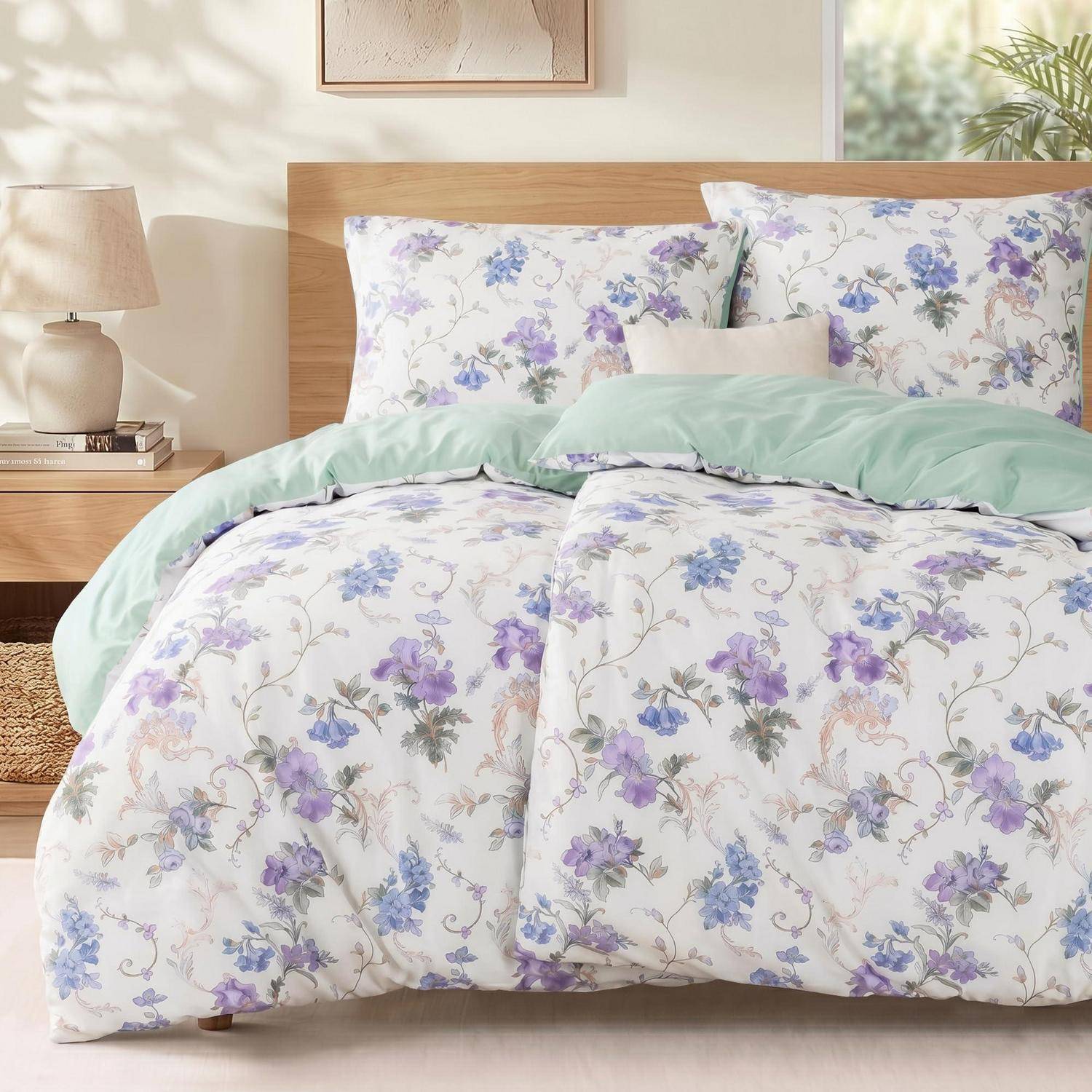 Ein ordentlich gemachtes Bett mit einer pastellfarbenen Blumensteppdecke, passenden Kissen und einer mintgrünen Decke in einem hellen, gemütlichen Schlafzimmer.