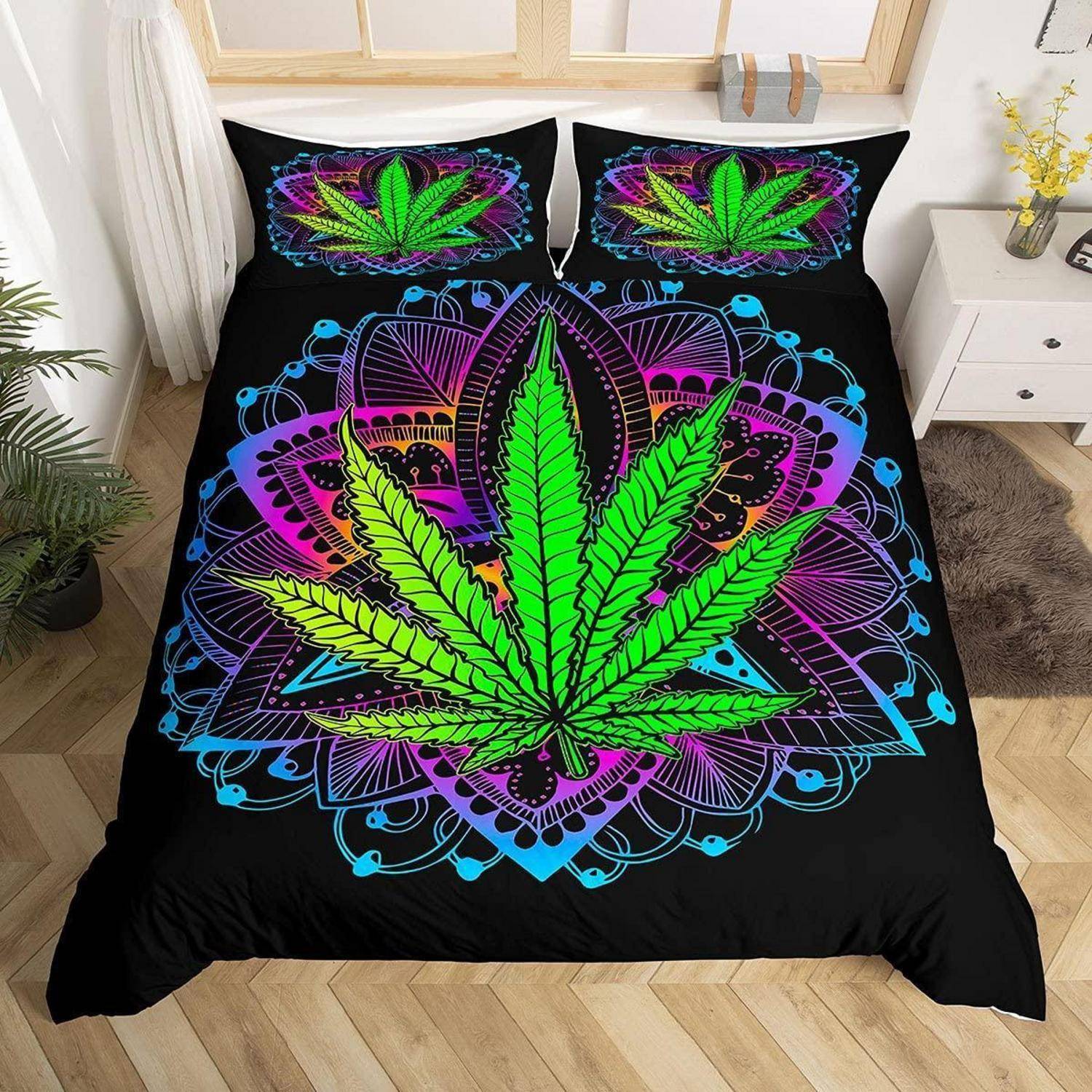 Bett mit schwarzer Bettdecke und Kissen mit großem Neon-Stil-Cannabisblatt-Design in Grün, Lila und Blau.