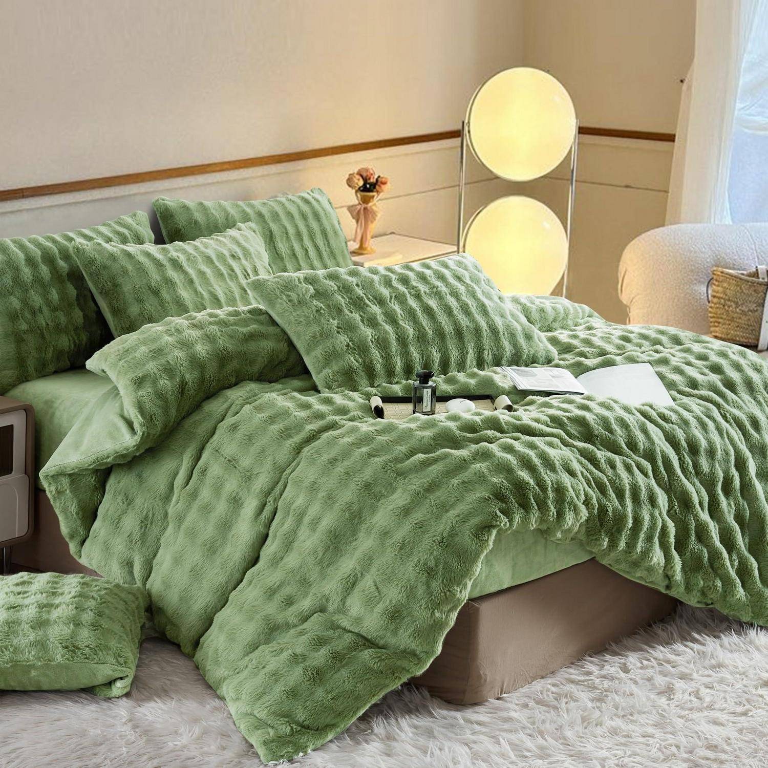 Gemütliches Schlafzimmer mit einem Bett, das in strukturierter Salbeigrüner Bettwäsche und passenden Kissen eingedeckt ist, beleuchtet von zwei runden Stehlampen neben einem kleinen Nachttisch.