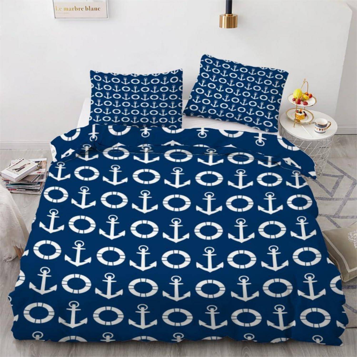 Ein Bett mit blau-weißer Bettwäsche mit Ankermuster und passenden Kissen in einem minimalistischen Schlafzimmer.