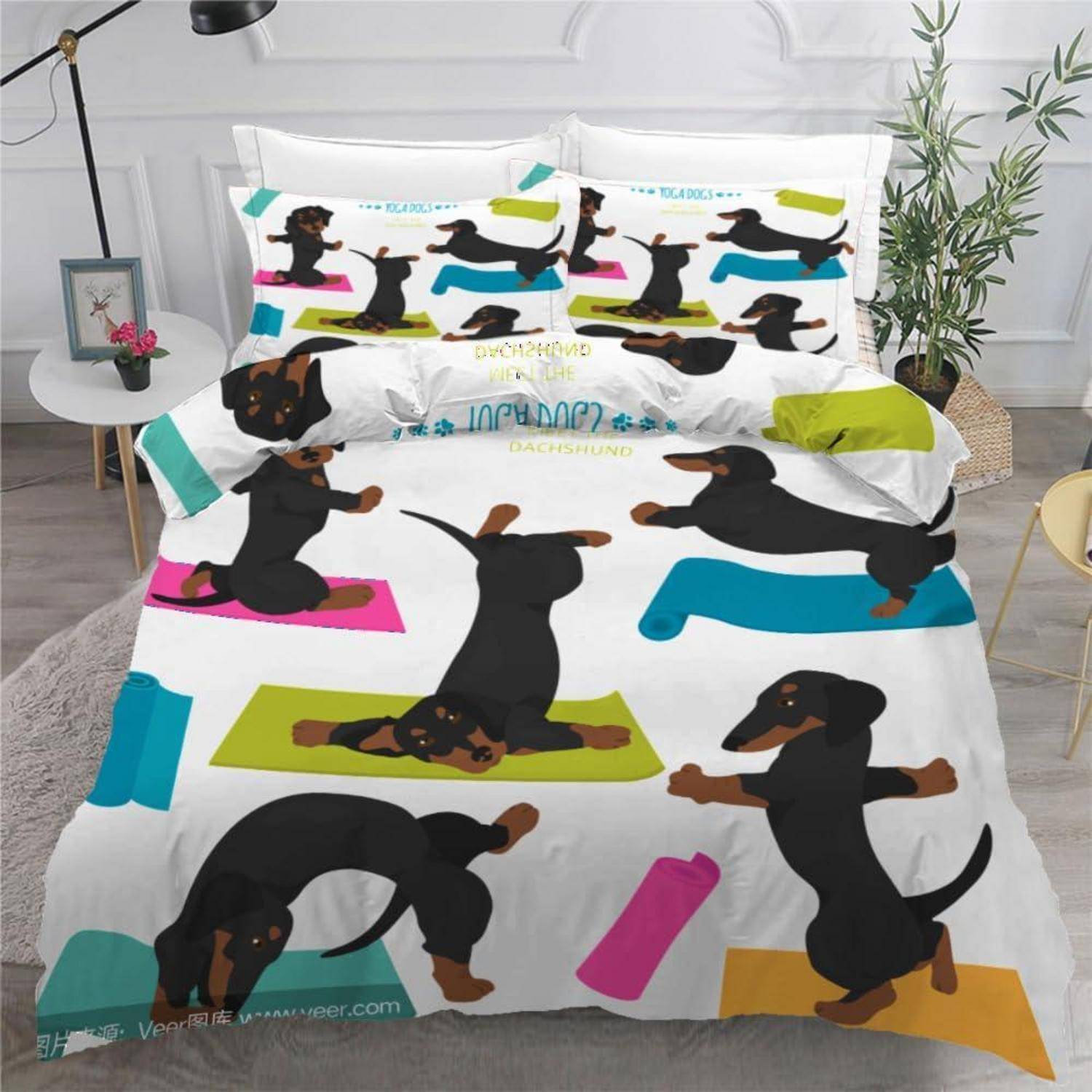 Ein Bett mit einer Dackel-Bettwäsche und Kissen, bedeckt mit farbenfrohen Illustrationen von schwarzen Dackeln in verspielten Posen auf weißem Hintergrund.