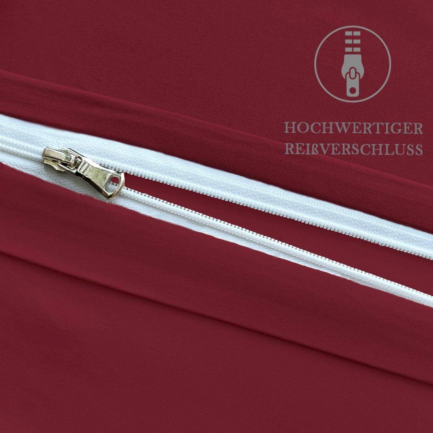 Nahaufnahme einer burgunderfarbenen Tasche oder eines Stoffes mit einem weißen Reißverschluss und metallischem Schieber, beschriftet mit "HOCHWERTIGER REIßVERSCHLUSS"", was einen hochwertigen Reißverschluss anzeigt.