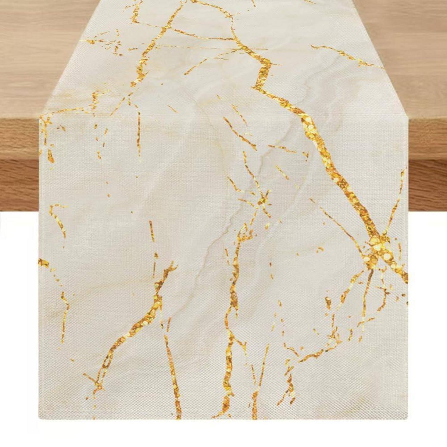 Weißer Tischläufer mit goldenem marmorähnlichem Muster auf einem Holztisch