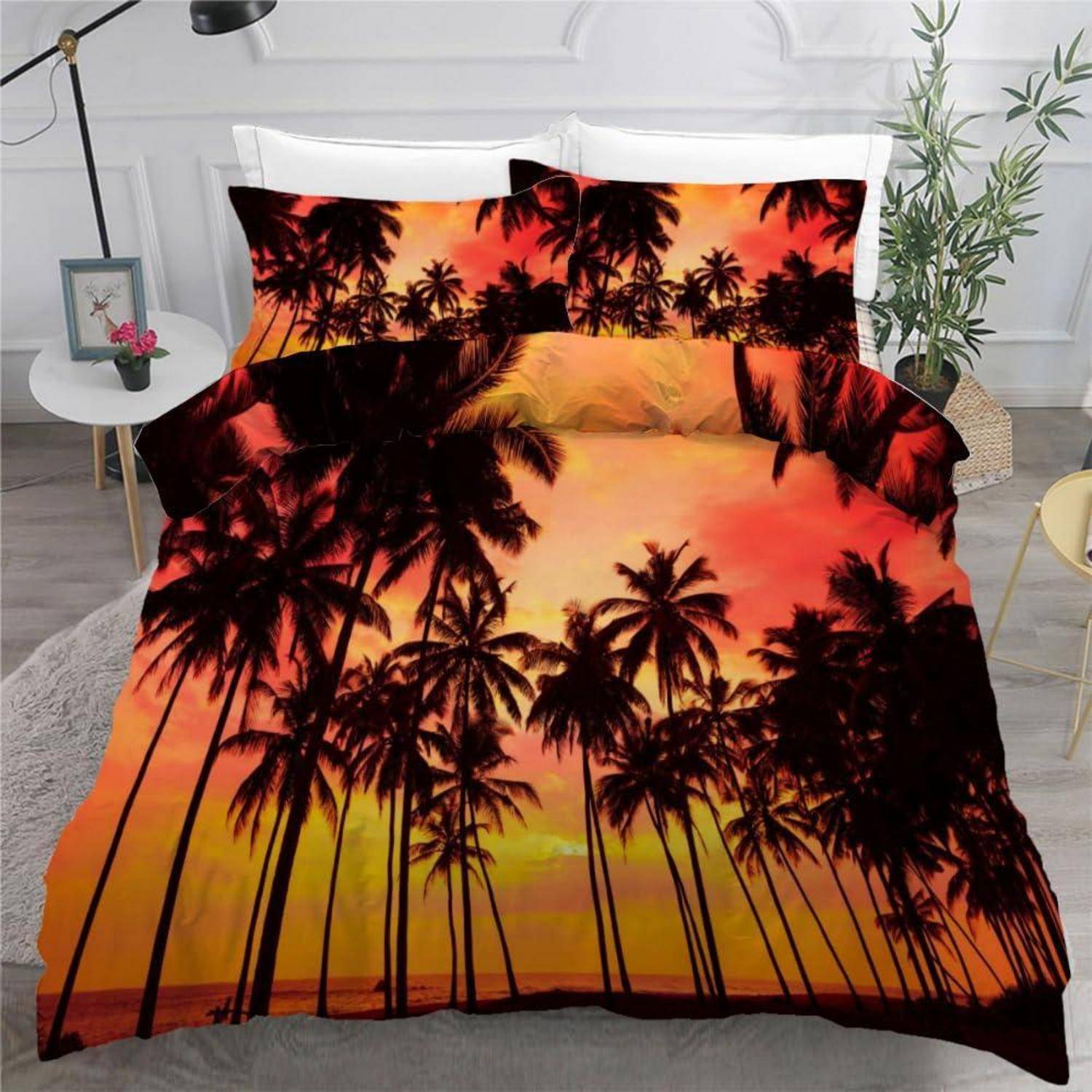 Palmenbett-Bettwäsche mit Sonnenuntergangsdruck mit orange-rotem Himmel und silhouettierten Palmen auf einem Bett in einem modernen Schlafzimmer.