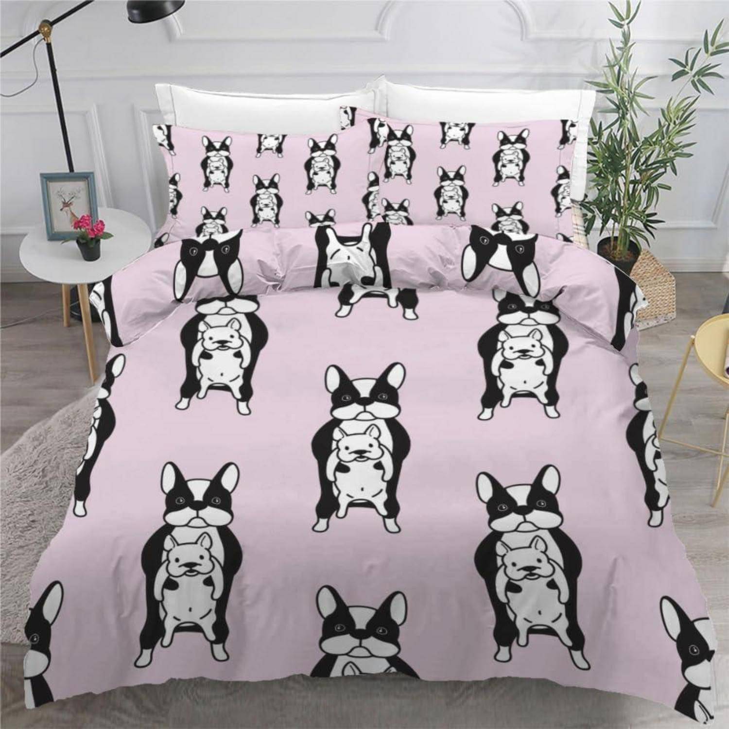 Rosafarbenes Bettwäsche-Set mit wiederholten schwarz-weißen Illustrationen von Französischen Bulldoggen auf einem Bett, einschließlich passender Kissenbezüge und Bettdeckenbezug.