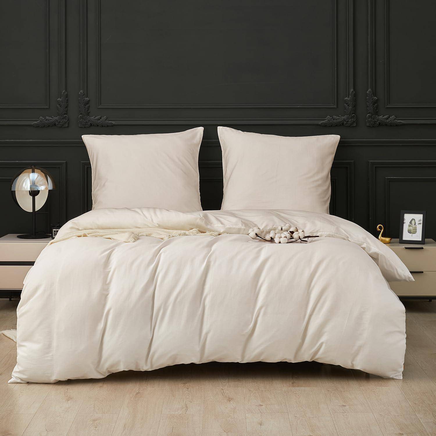 Cremefarbene Bettwäsche auf einem ordentlich gemachten Bett mit zwei Kissen, vor einer dunkel getäfelten Wand in einem minimalistischen Schlafzimmer.