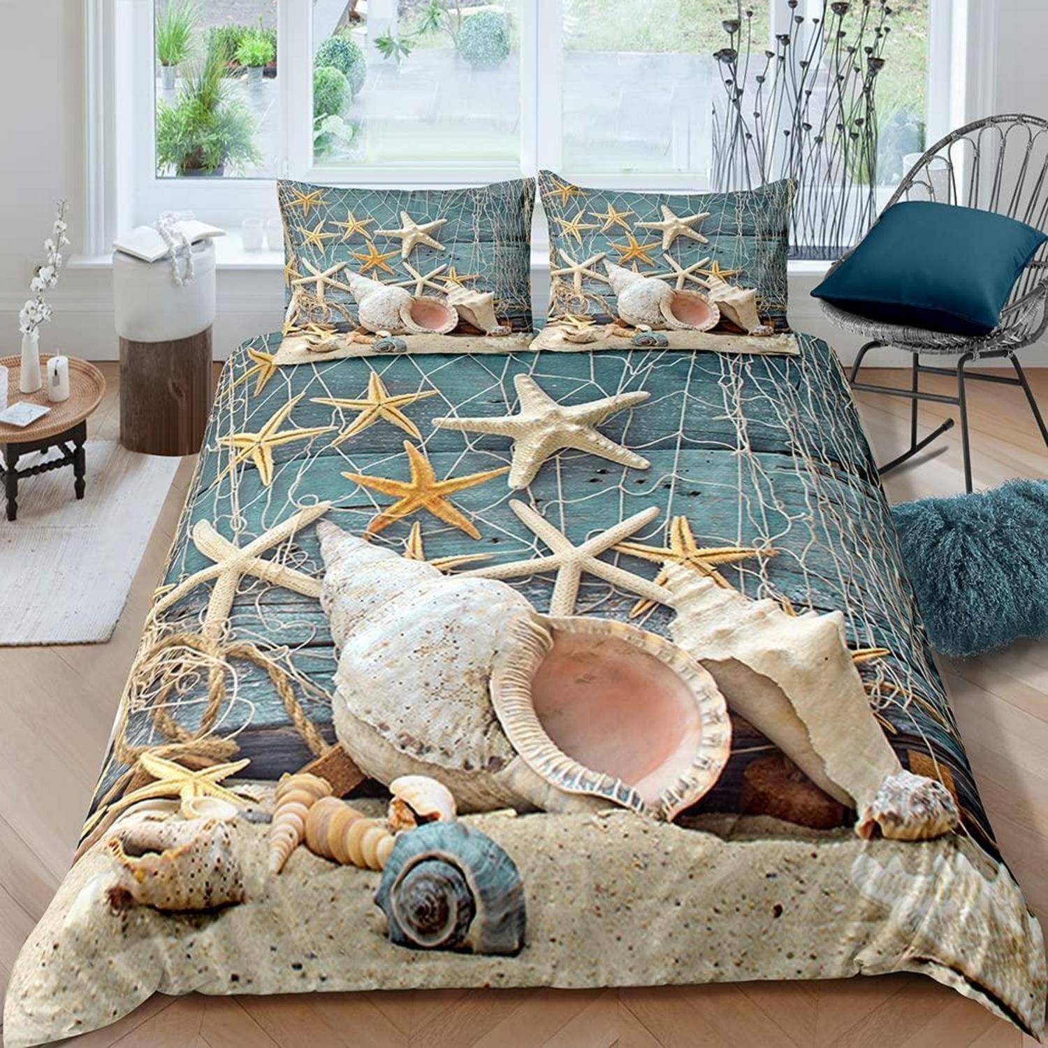 Ein strandthematisches Schlafzimmer mit Seestern- und Muschel-Bettwäsche auf einem Bett, gezeigt in einem hellen Raum mit Fenstern und einem Stuhl.