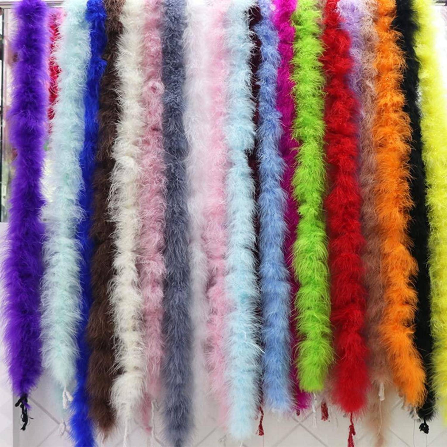 Vertikale Reihen von flauschigen Federboas in vielen leuchtenden Farben, darunter Lila, Blau, Weiß, Rosa, Grün, Rot, Orange und Schwarz.