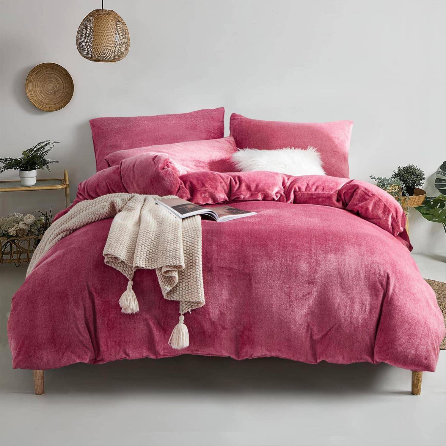 Rosiges Bett mit passendem Bettdecke und Kissen, beigefarbene Wurfdecke und weißes Akzentkissen in einer minimalistischen Schlafzimmereinrichtung.