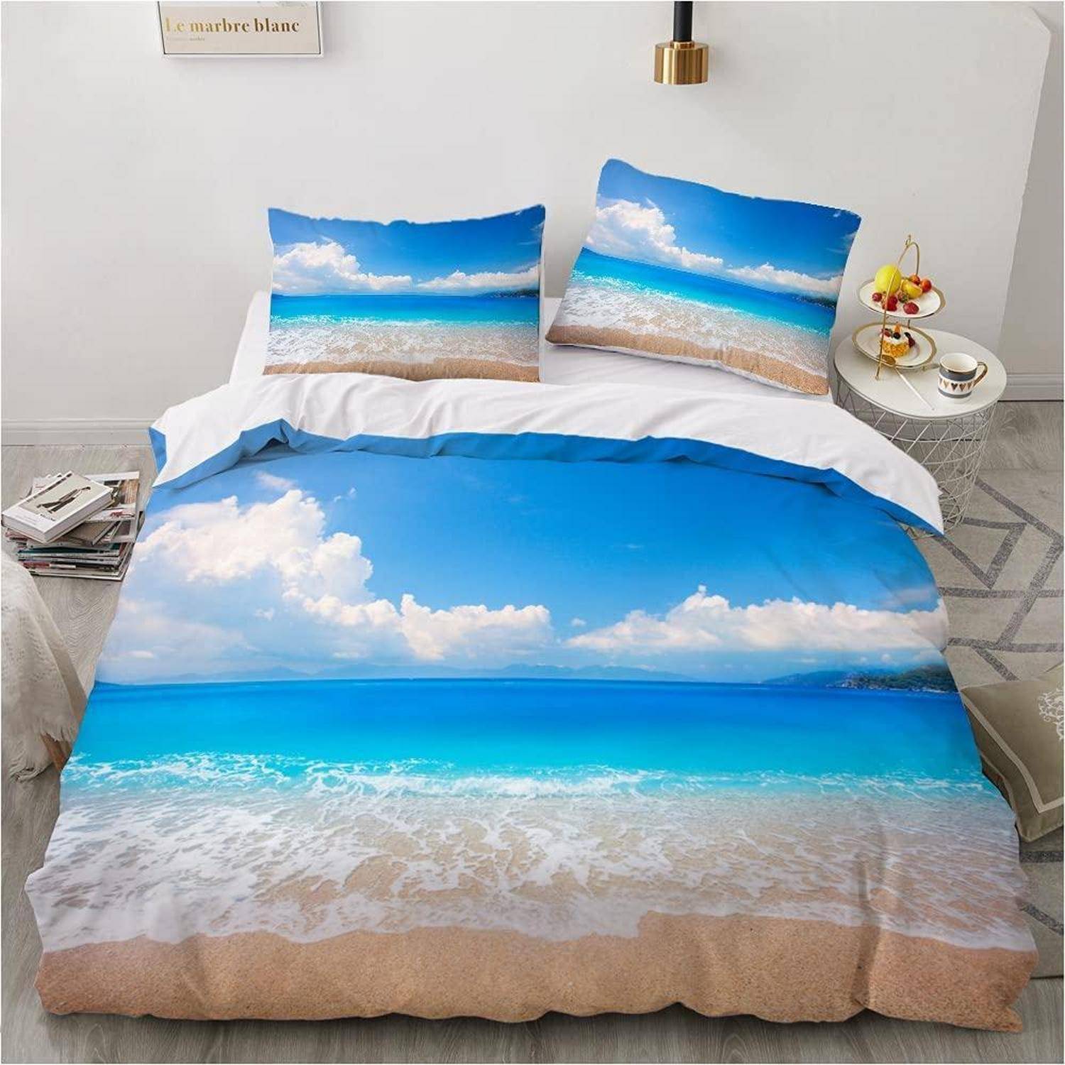 Bett mit blauem Ozean- und Himmelsdruck-Bettwäsche mit passenden Kissenbezügen, gezeigt in einem hellen Schlafzimmer.