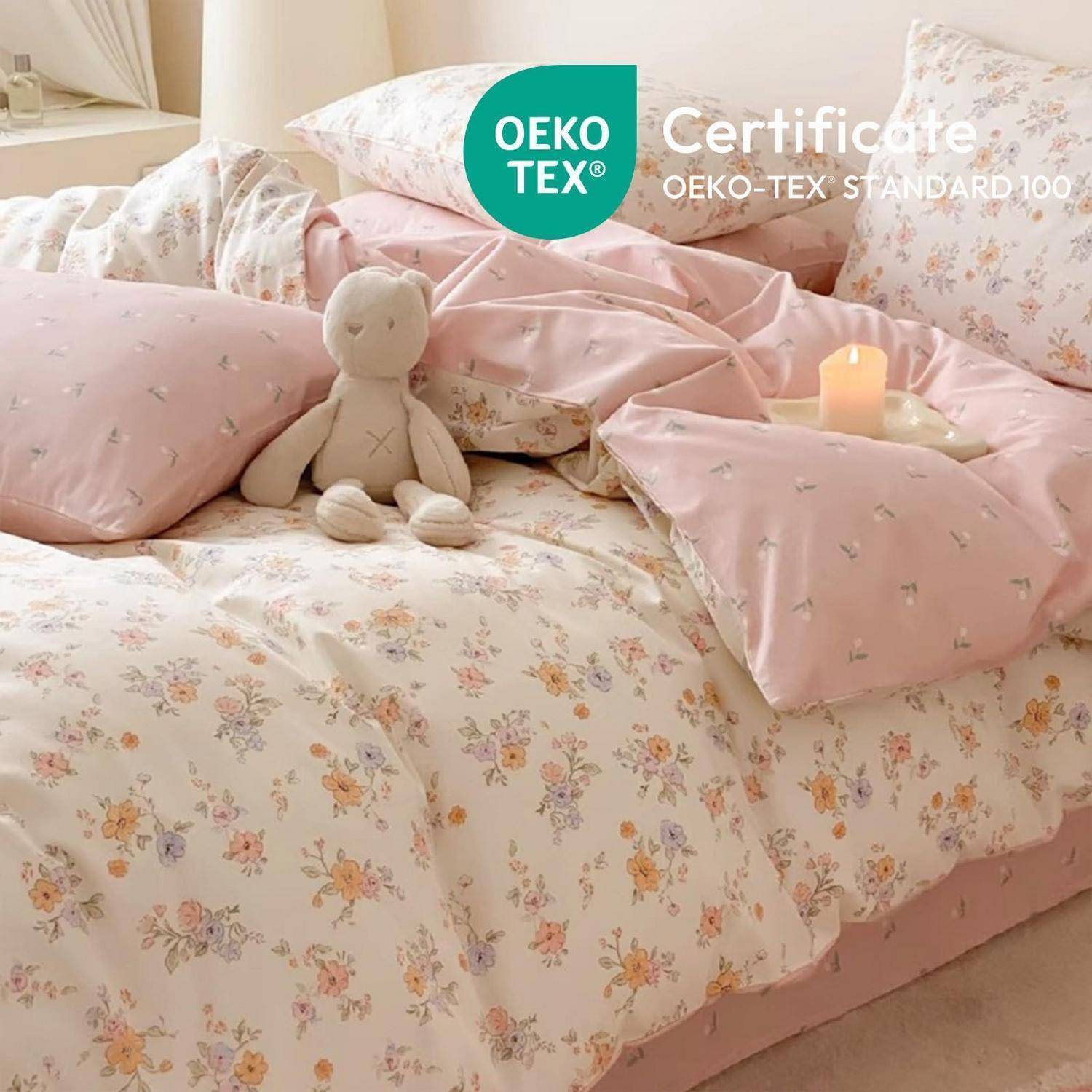 Ein florales rosa Bettwäscheset mit Kissen und einem Teddybär, gekennzeichnet mit „OEKO-TEX Certificate" und „OEKO-TEX STANDARD 100"".