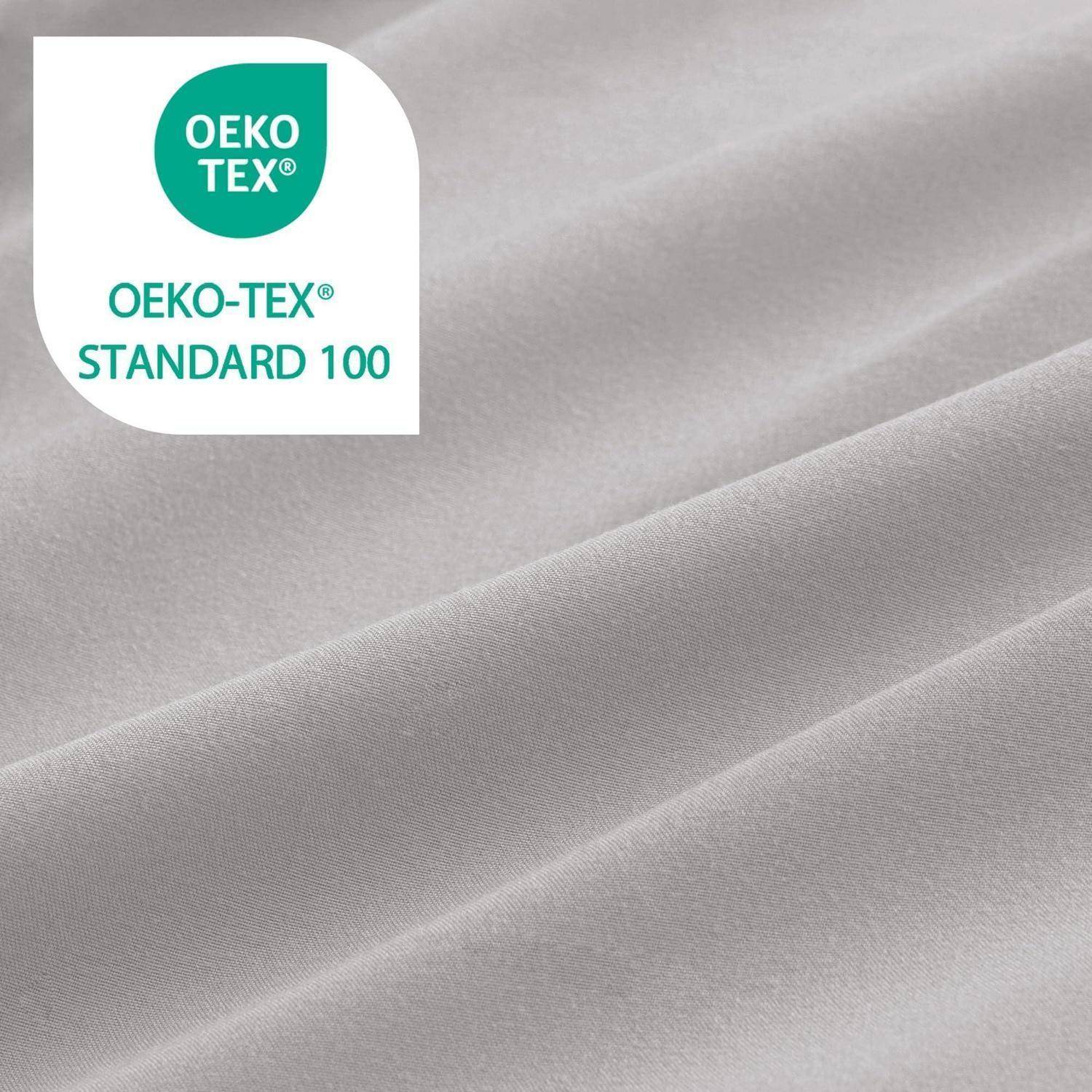 Nahaufnahme eines hellgrauen Stoffes mit einem OEKO-TEX Standard 100-Zertifizierungslogo oben links.