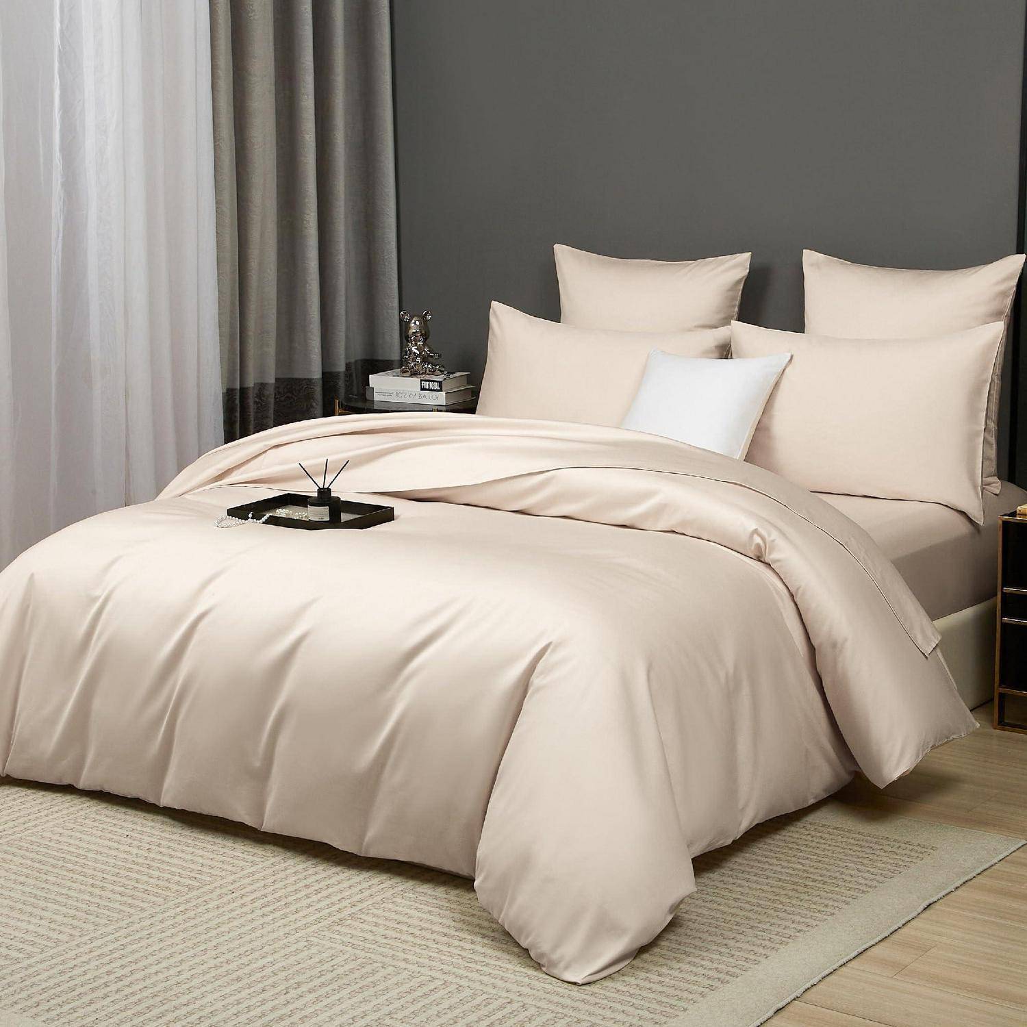Beiges Steppdecken-Set auf einem Bett mit passenden Kissen in einem minimalistischen Schlafzimmer