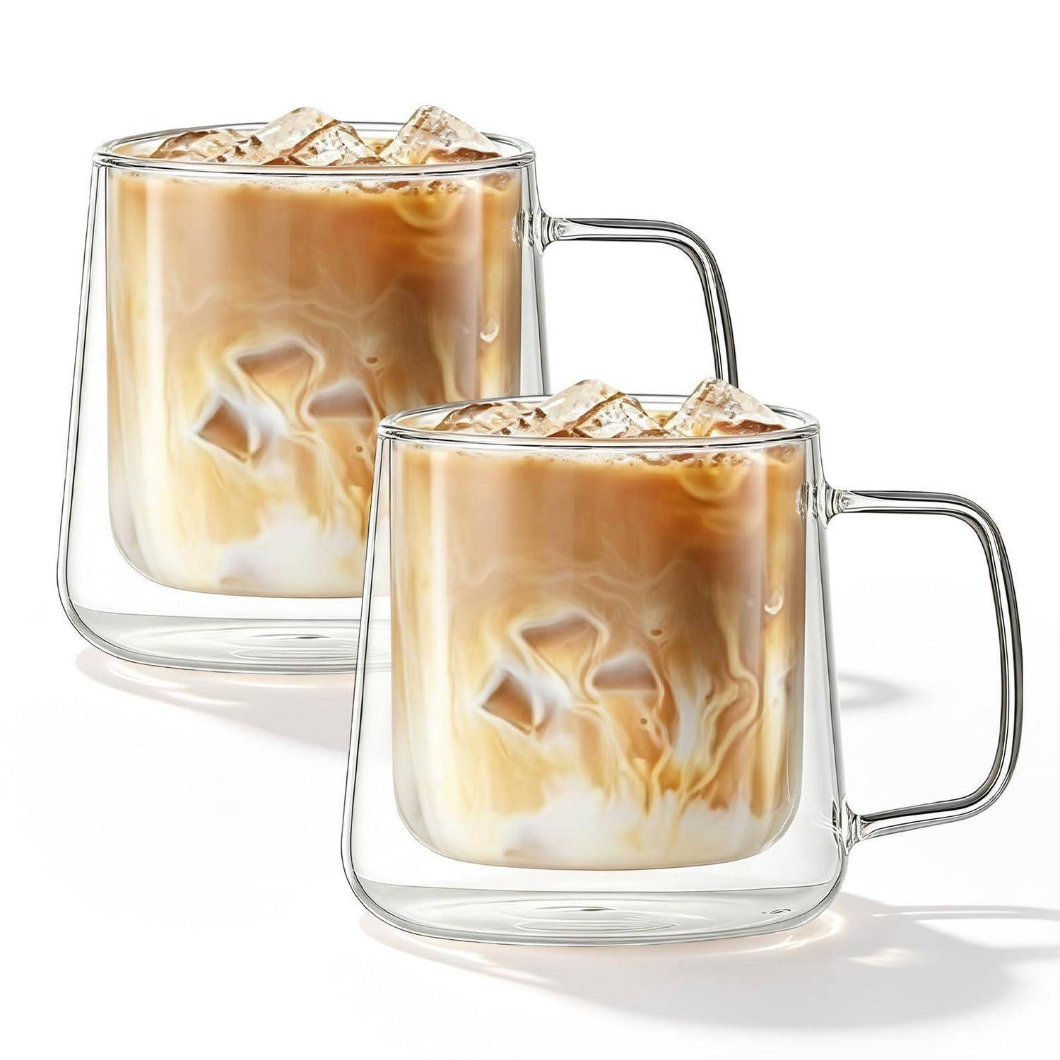Zwei durchsichtige Glastassen gefüllt mit Eiskaffee mit Milch oder Milchkaffee, die geschwungene Sahne- und Kaffee-Schichten zeigen.