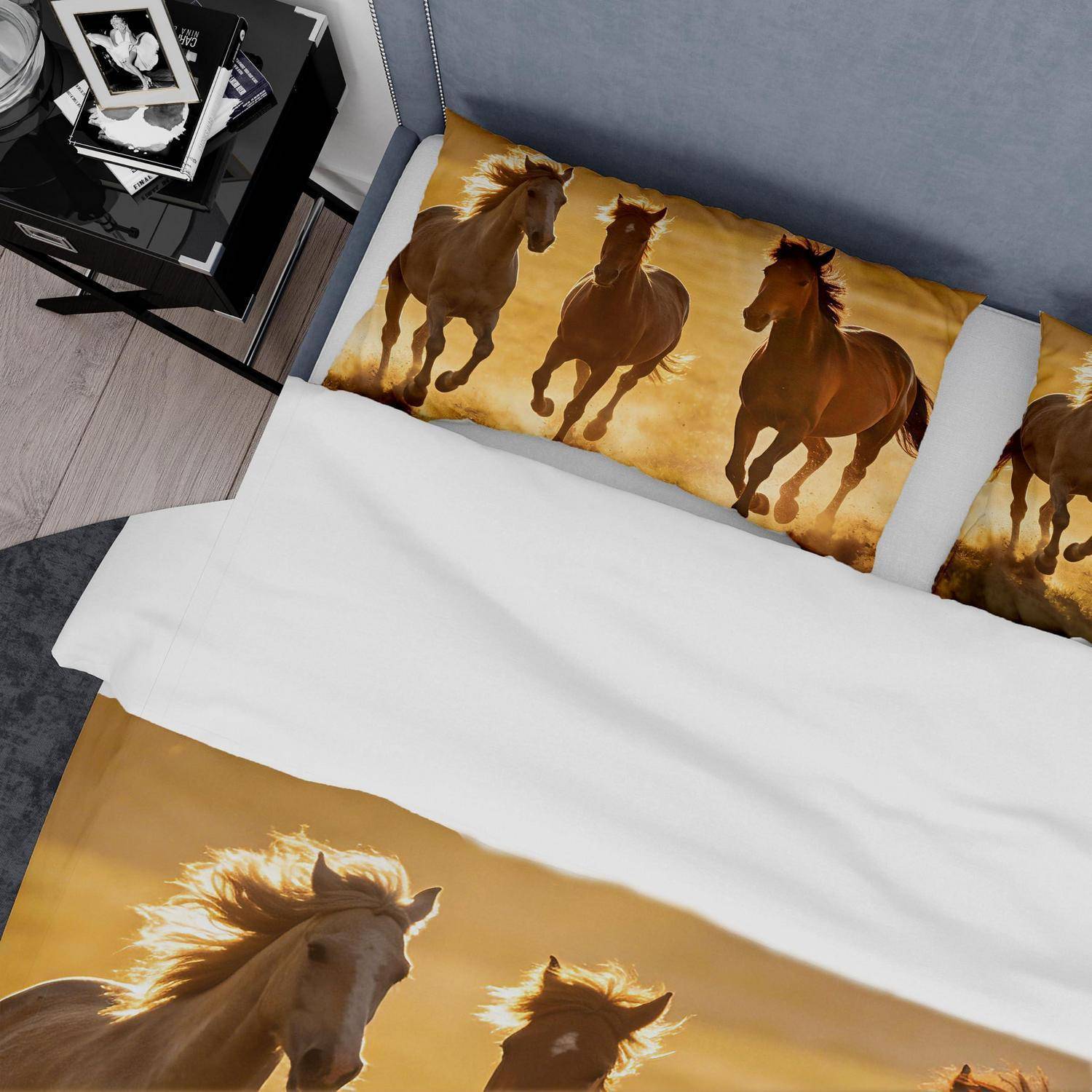 Bett mit pferdegestalteter Bettwäsche mit galoppierenden Pferden auf dem Kissen und der Decke, neben einem schwarzen Nachttisch mit gerahmten Fotos.