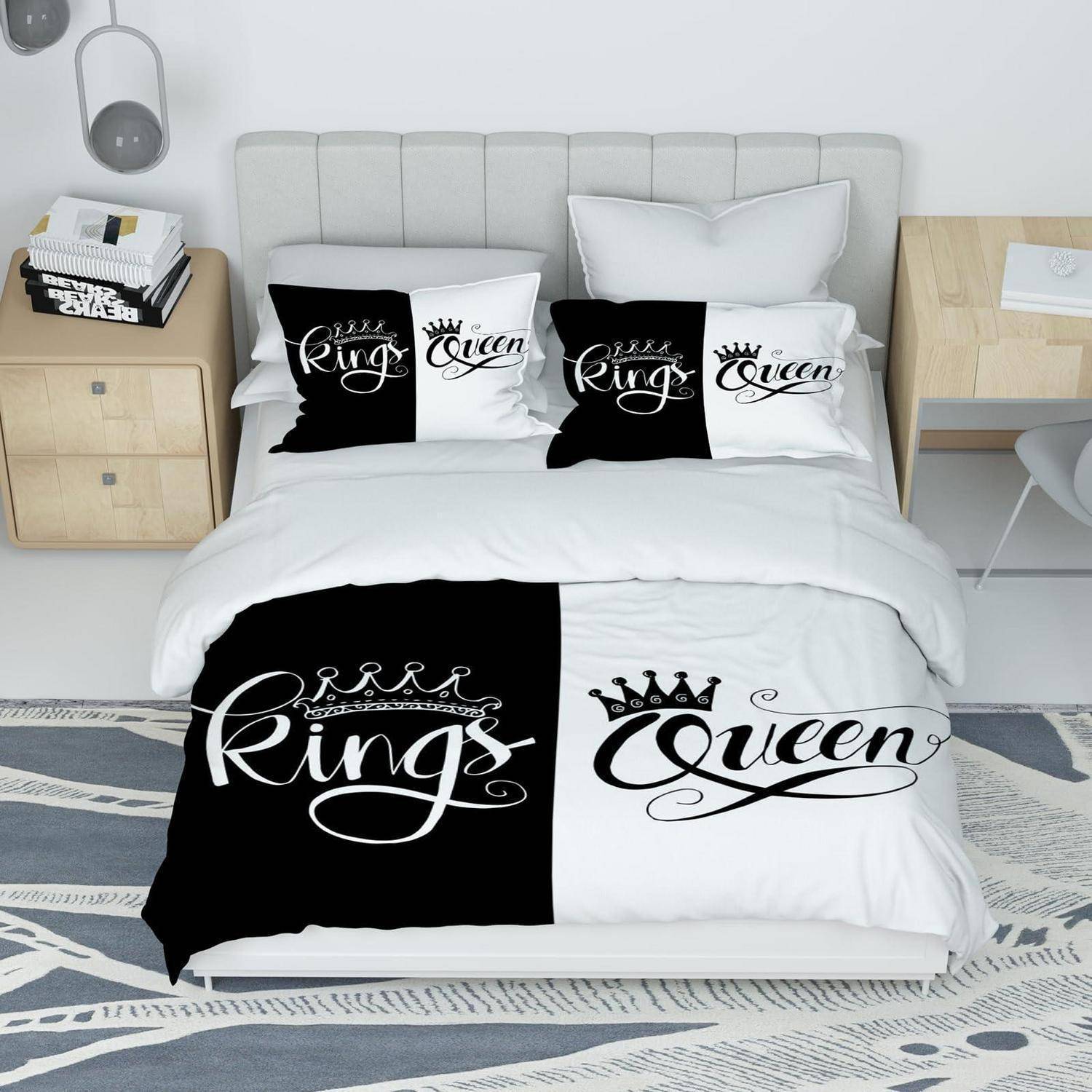 Bett mit schwarz-weißer Bettwäsche mit Aufschriften „King" und „Queen"", Kissen und Decke in einem modernen Schlafzimmer.
