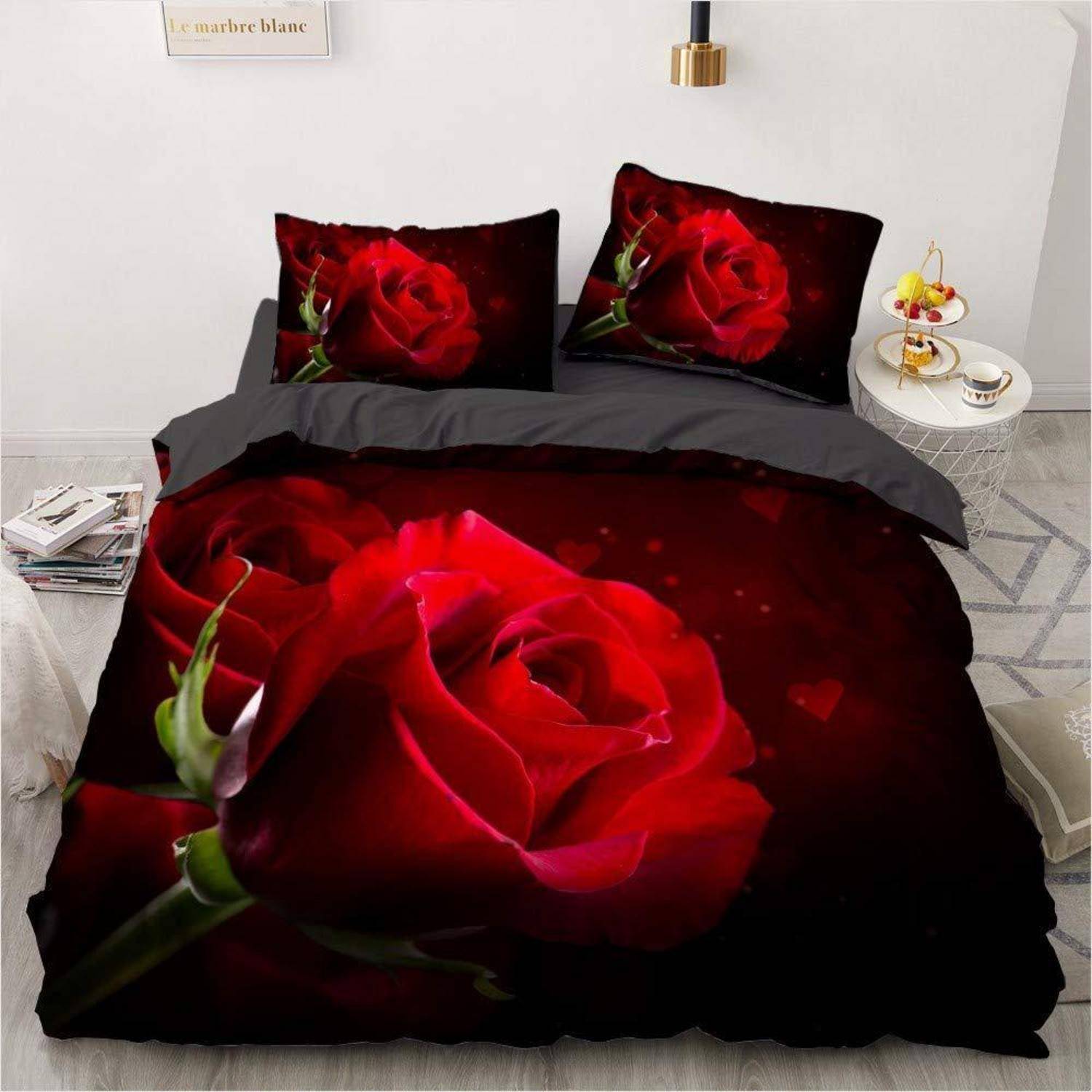 Bett mit schwarzer Bettwäsche, bedruckt mit großen roten Rosen auf der Bettdecke und passenden Kissenbezügen in einem modernen Schlafzimmer.