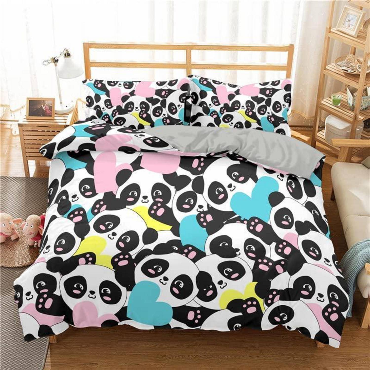 Bett mit Panda- und Herzmuster-Bettdecke und passenden Kissen in einem hellen, aufgeräumten Schlafzimmer.