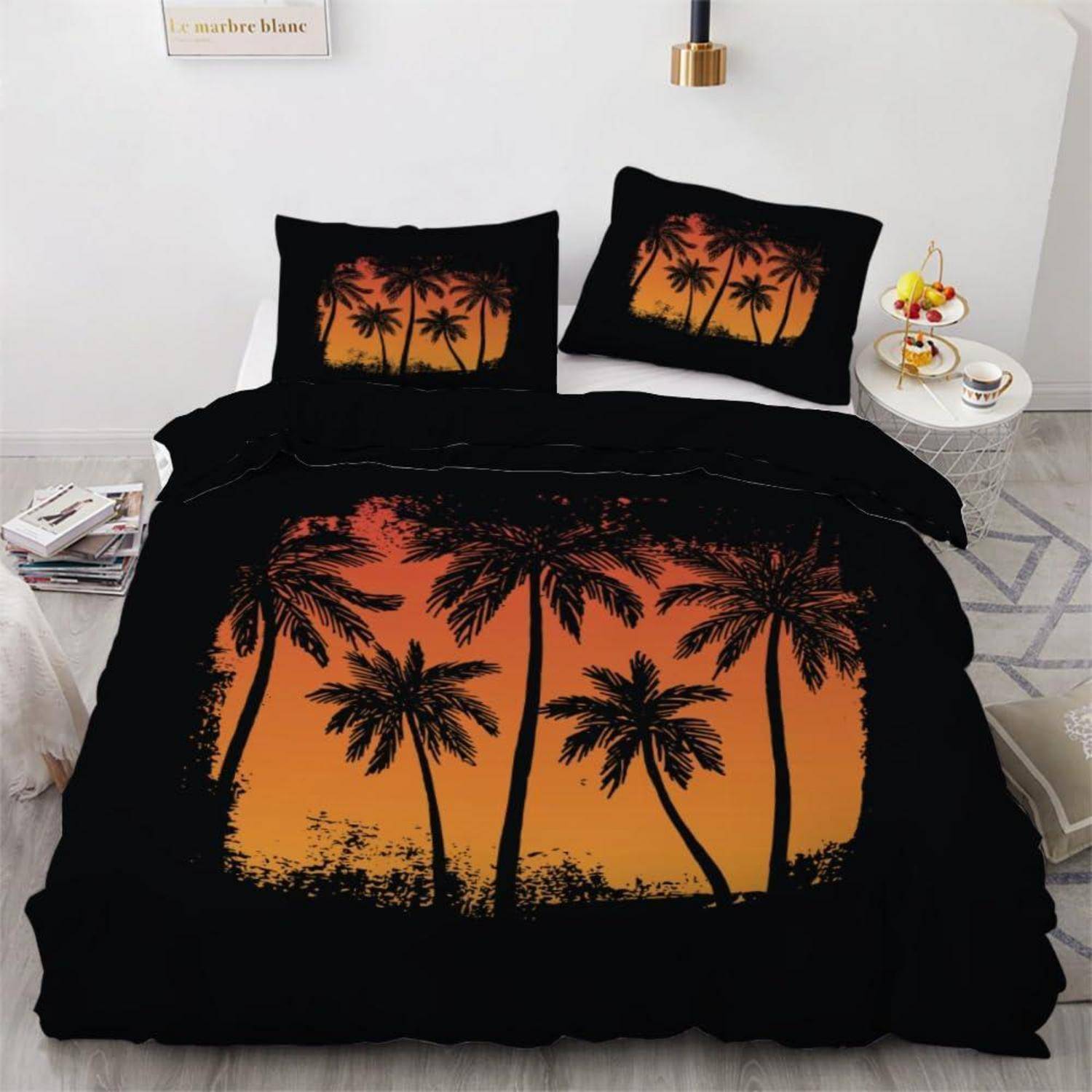 Bett mit schwarzer Bettwäsche mit orangefarbenen Sonnenuntergang-Palmensilhouetten auf der Bettdecke und passenden Kissen in einem modernen Schlafzimmer.