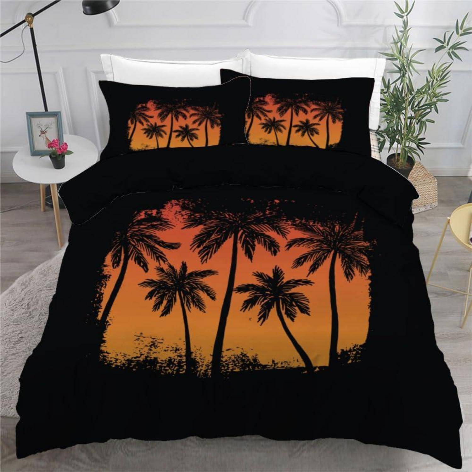 Schwarzes und orangefarbenes tropisches Palmenbetten-Set mit Sonnenuntergang-Silhouetten-Design auf einem Bett.