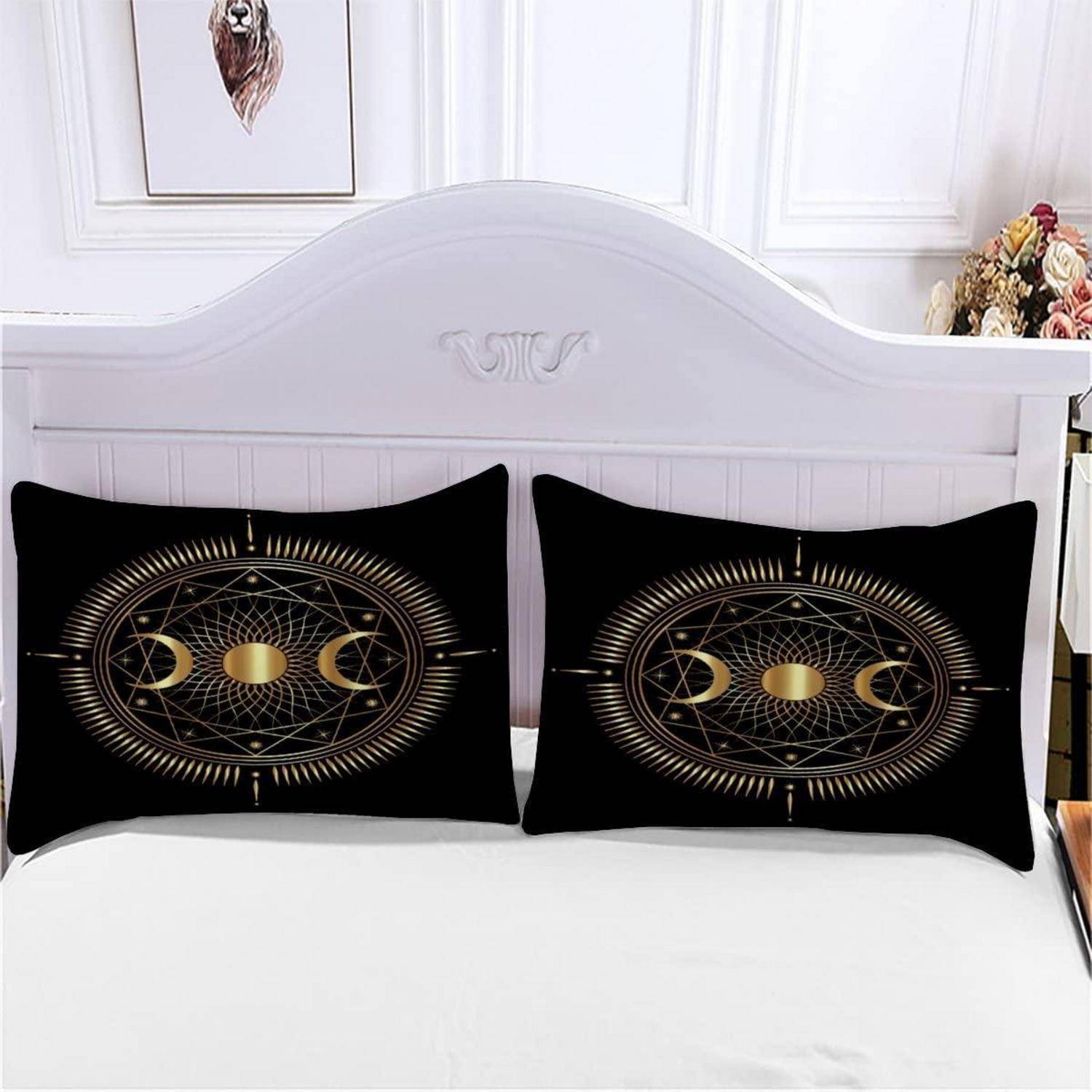 Weißes Bett mit zwei schwarzen Kissen mit goldfarbenen Mondphasen- und geometrischen Mandalamuster