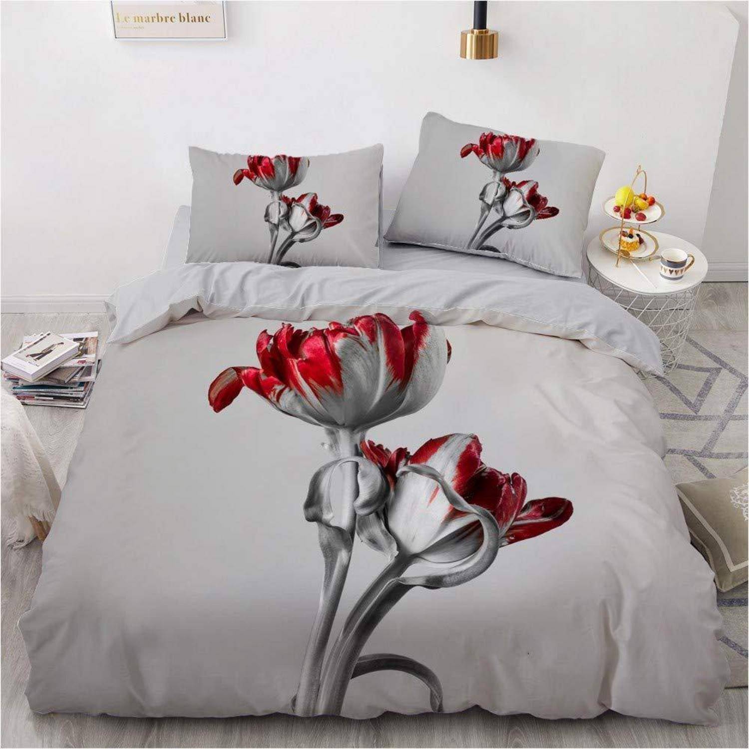 Bett mit hellgrauem Blumenbettdecke und passenden Kissen mit rot-grauen Blumen in einem minimalistischen Schlafzimmer.