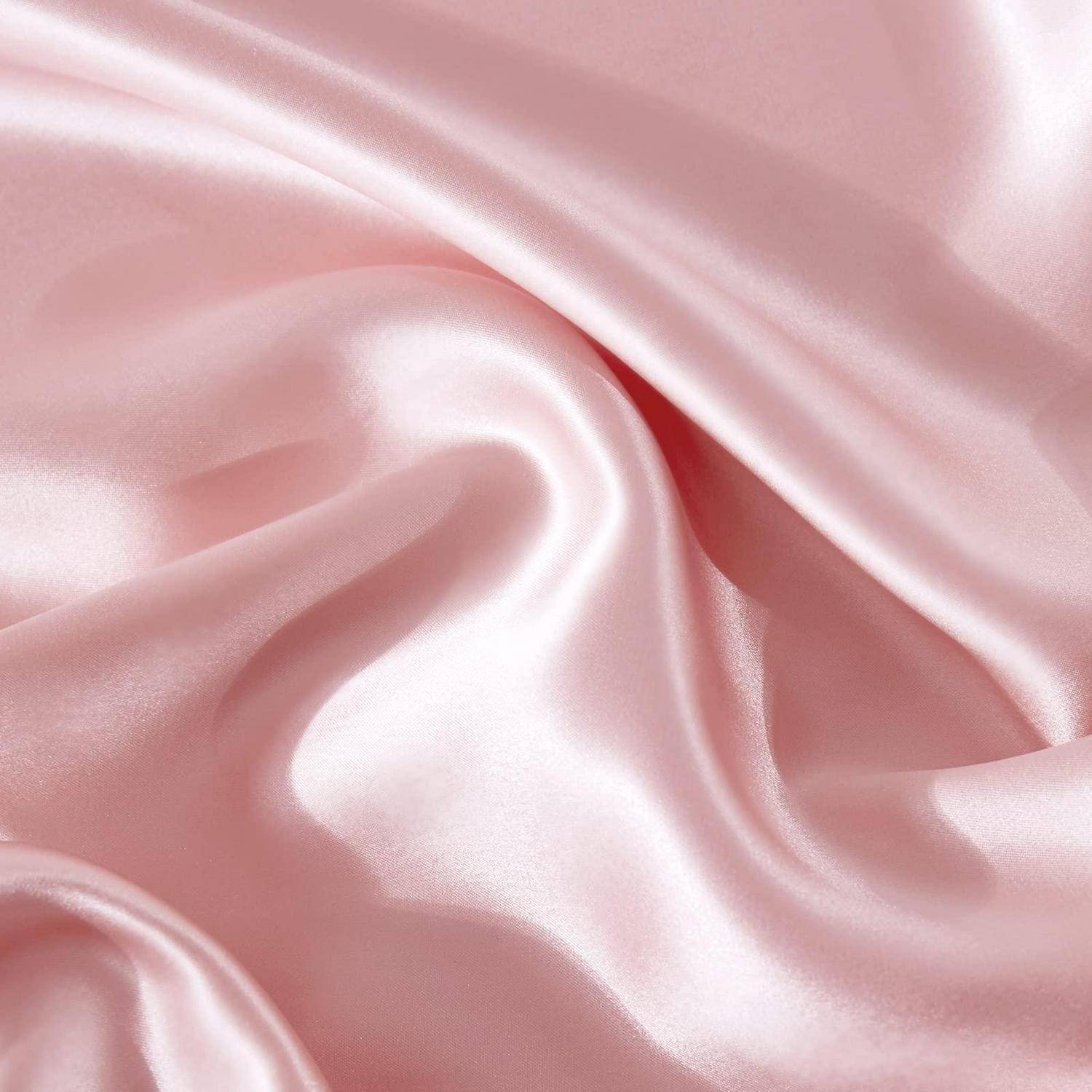 Nahaufnahme von seidig rosa Satinstoff mit sanften Falten und glänzender Oberfläche.