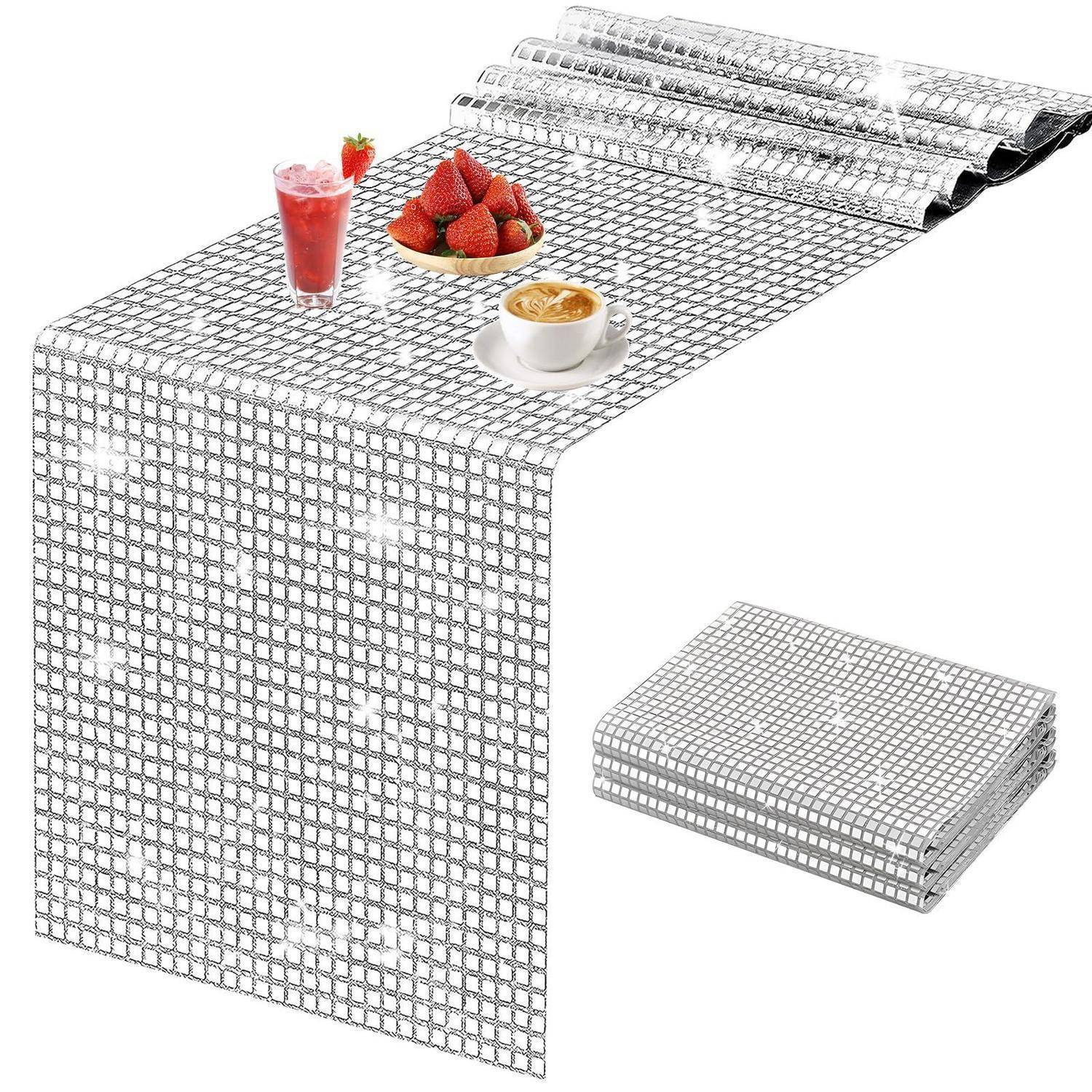 Silber-weiß karierter Tischläufer, der über einen Tisch drapiert ist, mit einem gefalteten Stapel desselben Läufers und Beispieldesserts darauf.