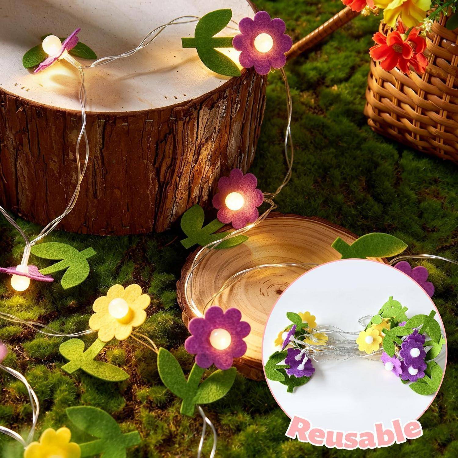 Blumenförmige Lichterketten mit grünen Blättern auf Moos, gezeigt rund um eine Holzscheibe und einen Korb; Inset hebt wiederverwendbares Blumengirlande hervor