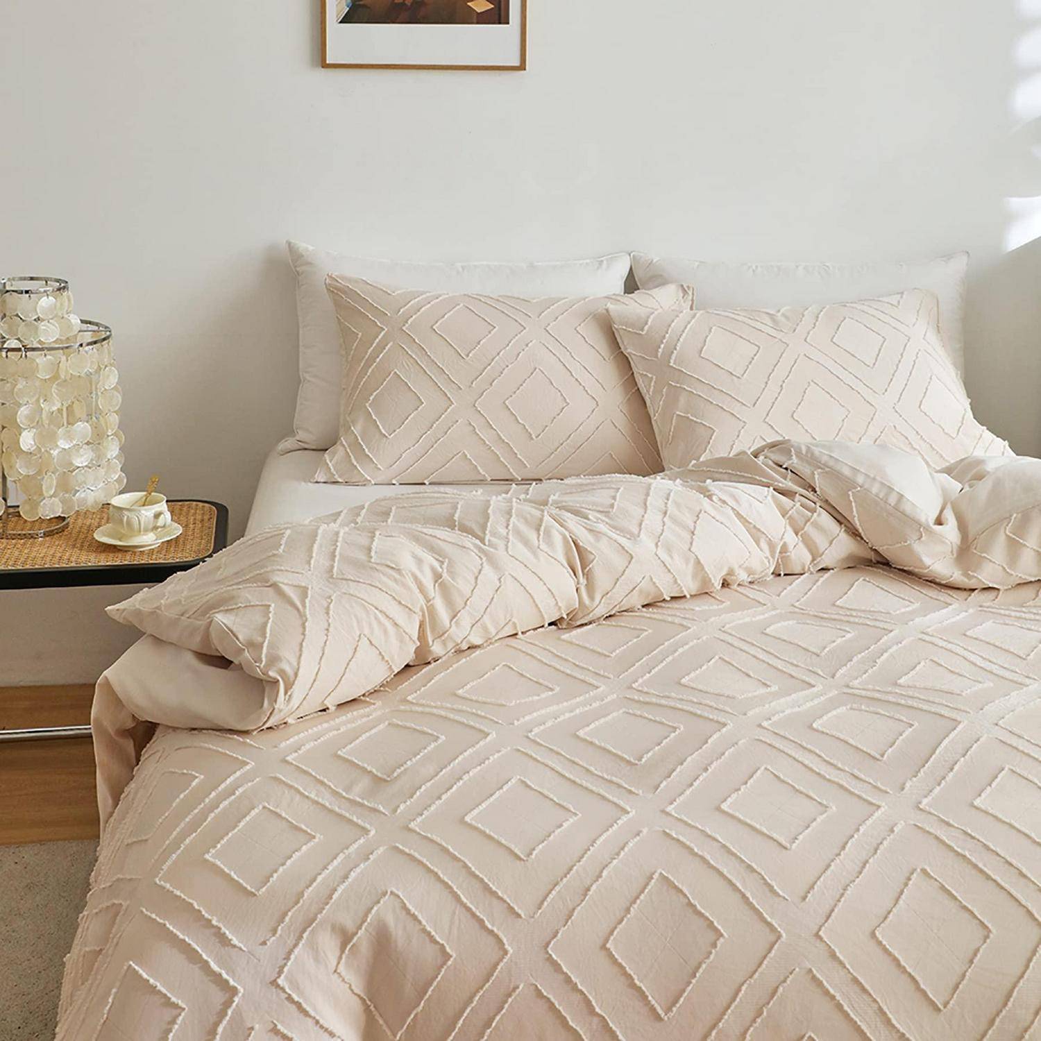 Beige geometrische Bettwäsche mit Muster auf einem ordentlich gemachten Bett, mit passenden Kissen und einer Decke in einem minimalistischen Schlafzimmer.