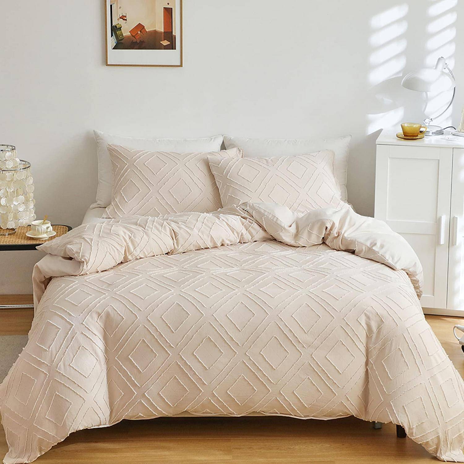 Ordentlich gemachtes Bett mit cremefarbener geometrischer Bettwäsche und Kissen in einem hellen, minimalistischen Schlafzimmer mit einem Nachttisch und einer Lampe.