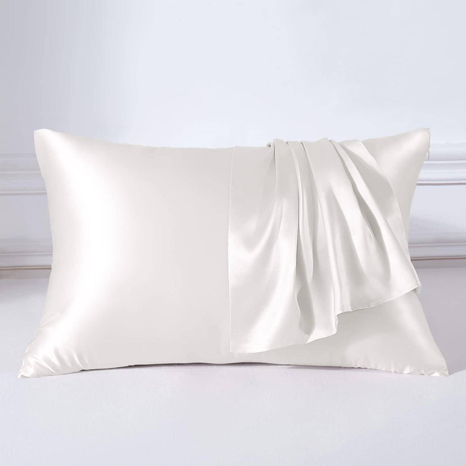 Weiße Satin-Kissenbezug über einem weißen Kissen auf einem Bett drapiert, gezeigt vor einem hellen, neutralen Hintergrund.