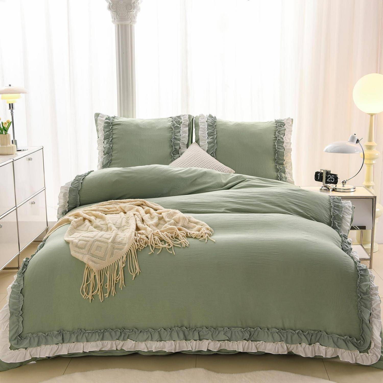 Ein sauber gemachtes Bett mit Salbeigrünem Rüschenbettwäsche und Kissen in einem hellen Schlafzimmer, mit einer beigen Wurfdecke darüber drapiert.