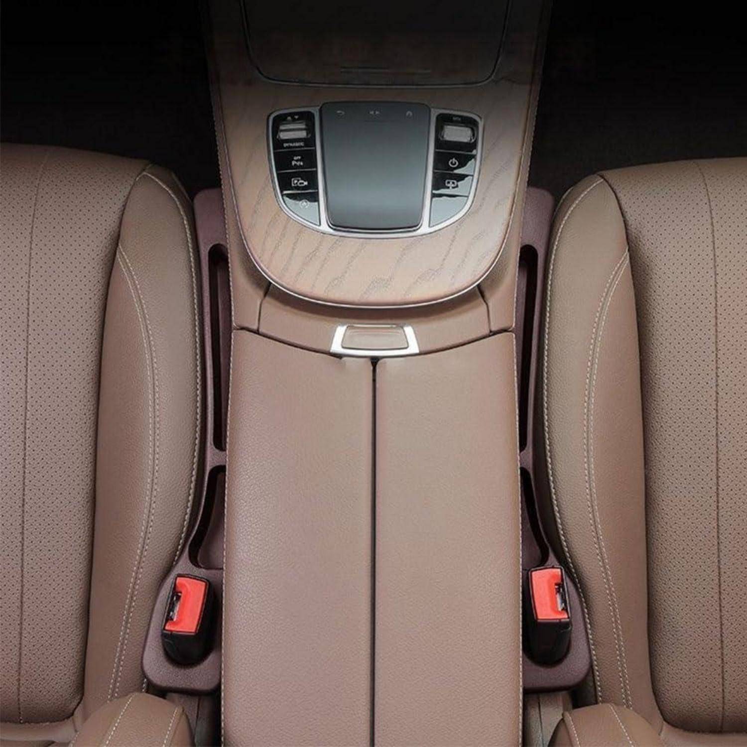Nahaufnahme einer beigefarbenen Mittelkonsole eines Autos zwischen zwei Vordersitzen, die den Getränkehalter-/Armlehnenbereich und die Bedienelemente in der Nähe des Armaturenbretts zeigt.