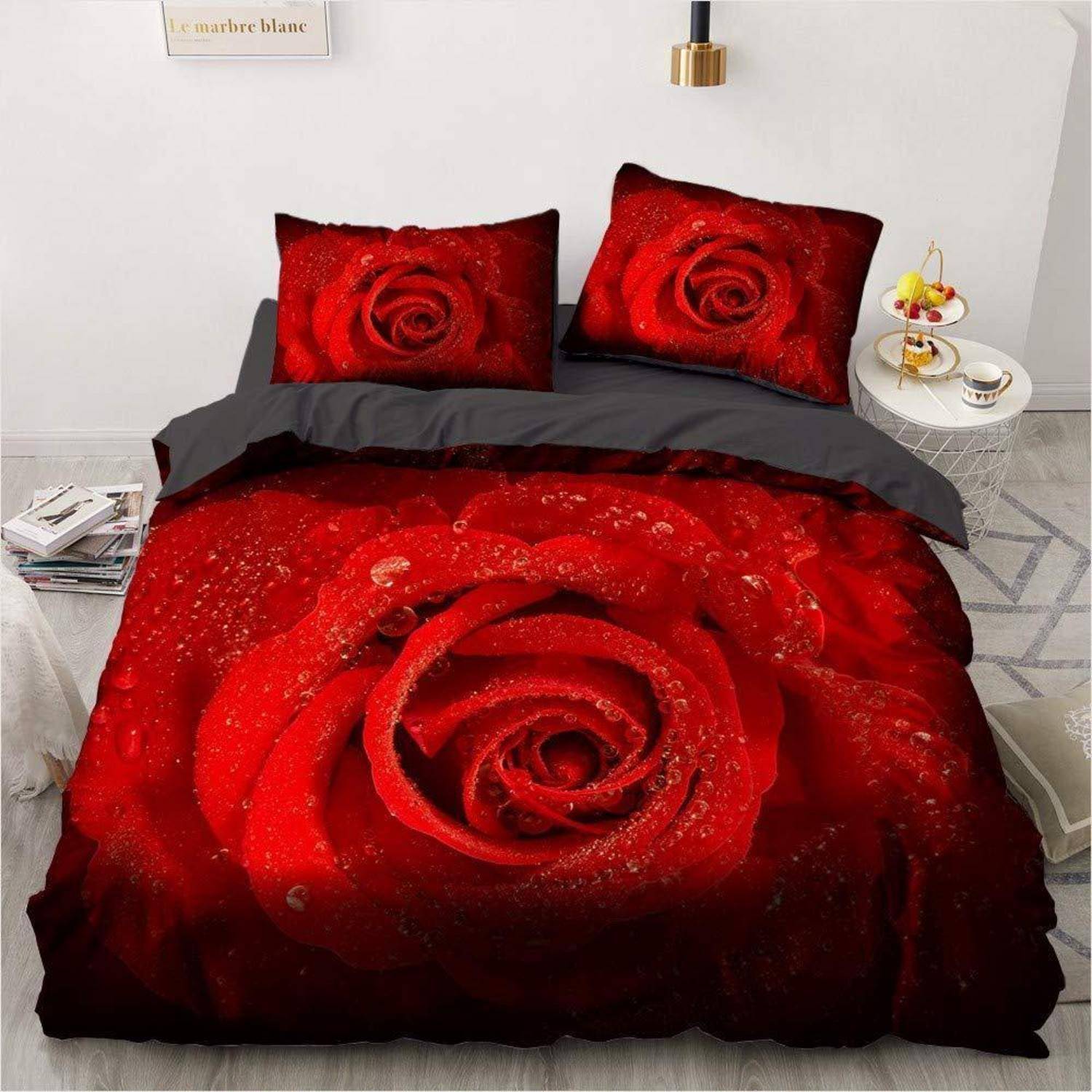 Ein Bett mit rotem Rosenmuster-Bettwäsche und passenden Kissenbezügen, mit einem großen Rosendesign auf der Bettdecke.