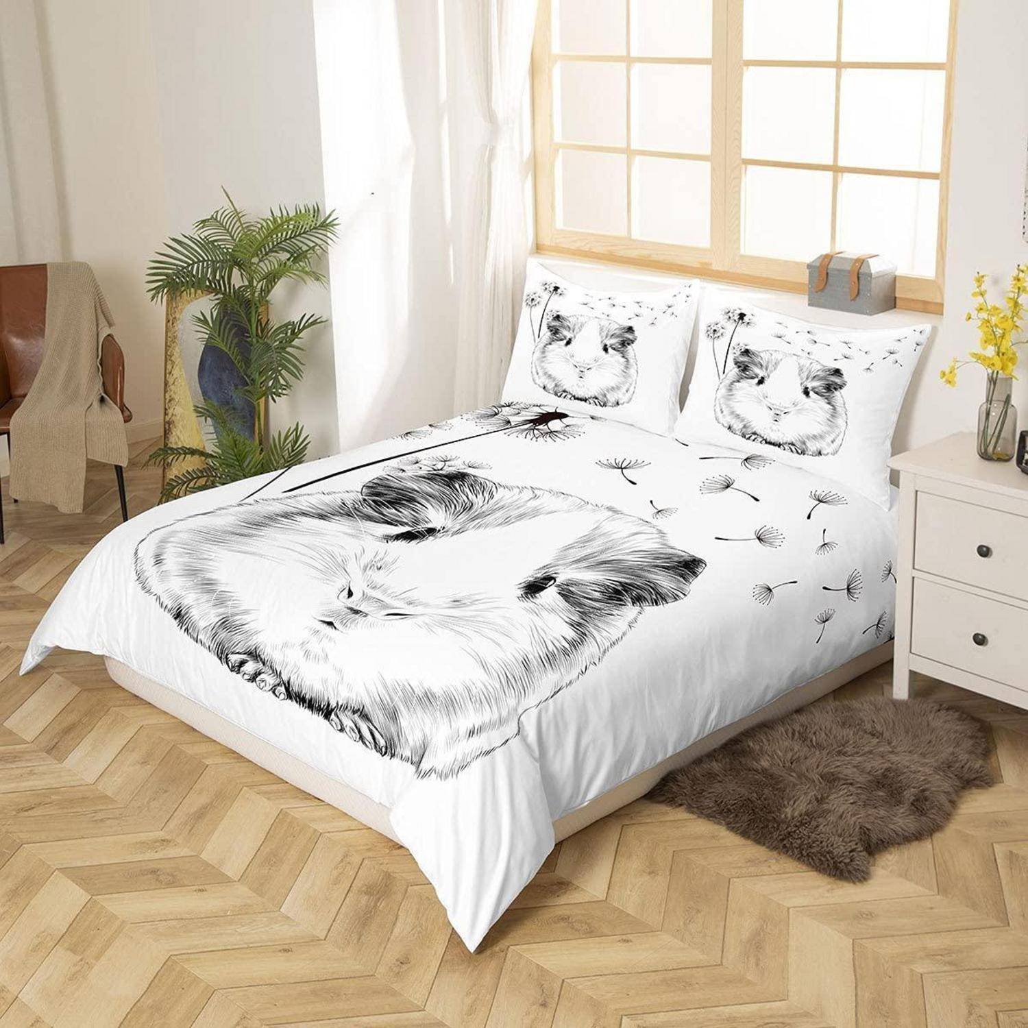 Weißes Bett mit schwarzer Katzengesicht-Bettwäsche und passenden Kissen in einem hellen Schlafzimmer neben einem Fenster, Nachttisch, Pflanze und Stuhl.