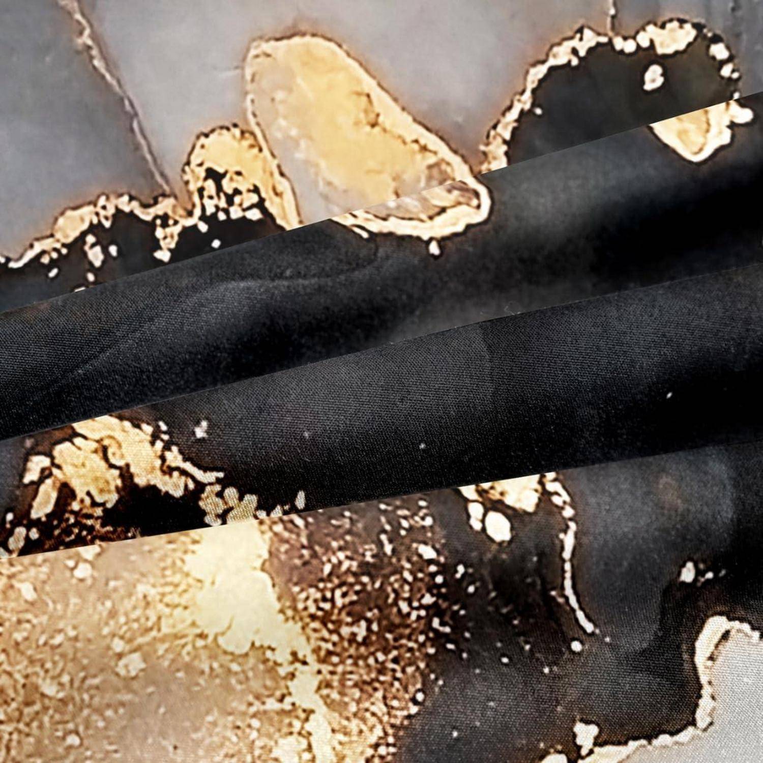Nahaufnahme von schwarzem gefalteter Stoff mit einem abstrakten Gold-, Beige- und Braunmuster darunter.