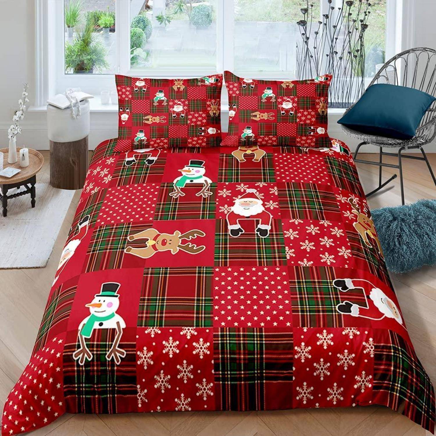 Bett in einem hellen Schlafzimmer mit roter Weihnachts-Patchwork-Bettwäsche, verziert mit Weihnachtsmann-, Schneemann- und Rentier-Mustern.