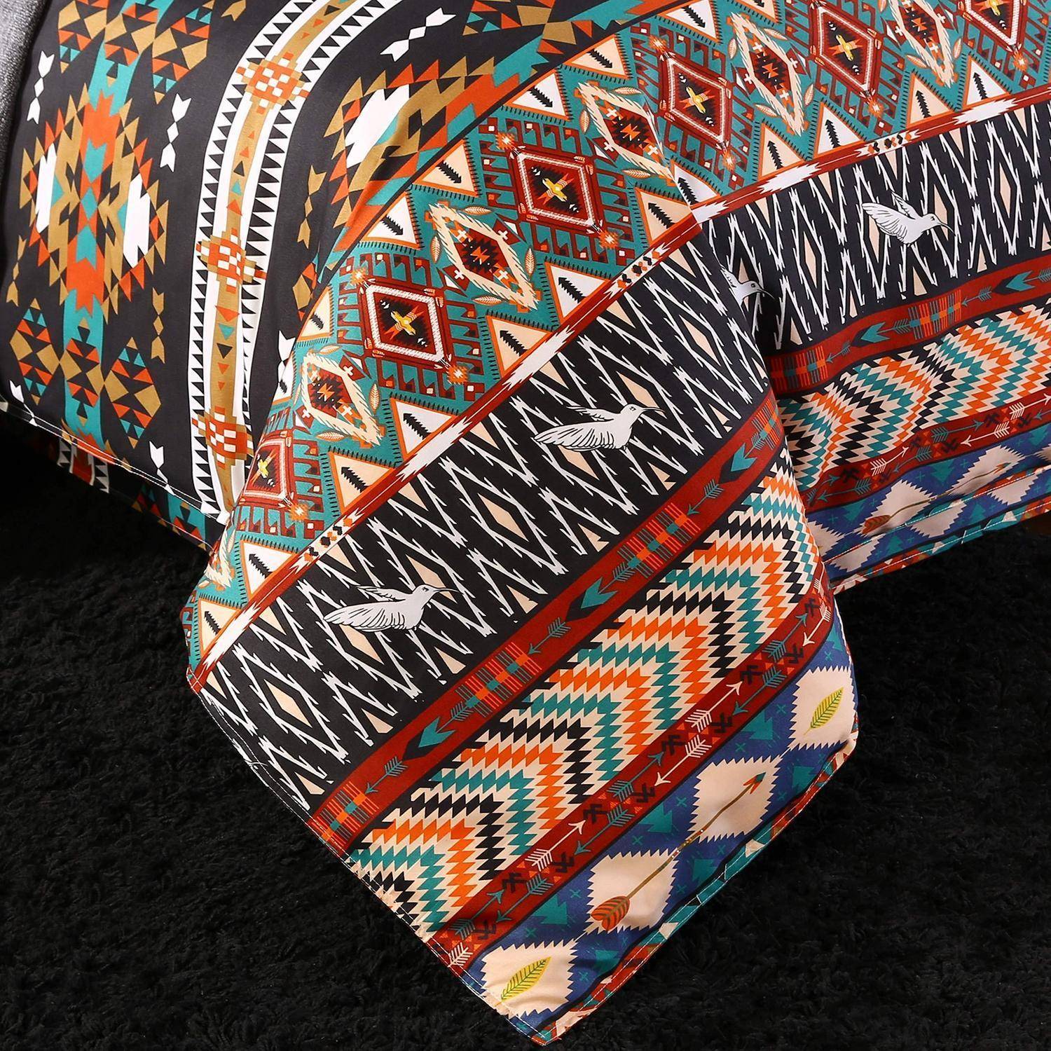 Nahaufnahme eines farbenfrohen gemusterten Stoffs mit geometrischen, Zickzack- und Vogelmotiven in Orange, Blaugrün, Schwarz und Weiß.